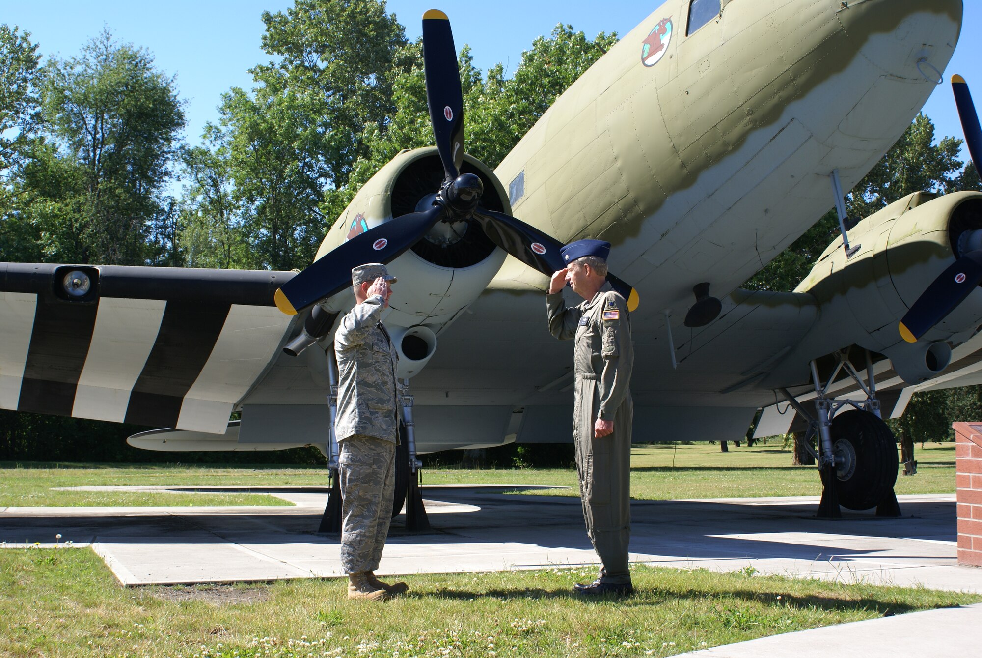 Tech. Sgt. Douglas Seekins is re-enlisted by his father, retired Lt. Col. Scott Seekins July 8 in front of an aircraft that his grandfather, Maj. Robert Seekins, flew during World War II.  (U.S. Air Force photo/Amn Leah Young)