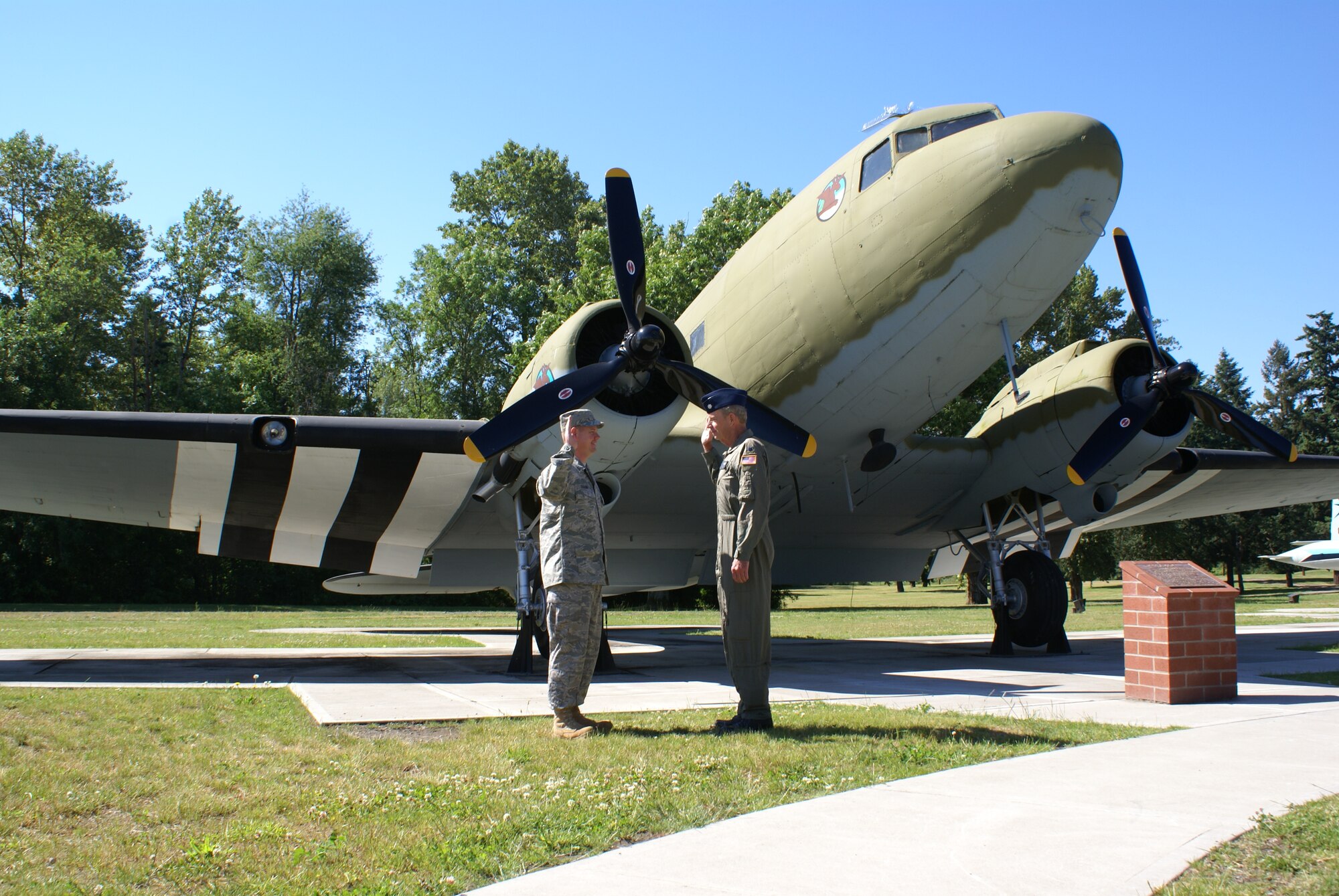 Tech. Sgt. Douglas Seekins is re-enlisted by his father, retired Lt. Col. Scott Seekins July 8 in front of an aircraft that his grandfather, Maj. Robert Seekins, flew during World War II.  (U.S. Air Force photo/Amn Leah Young)