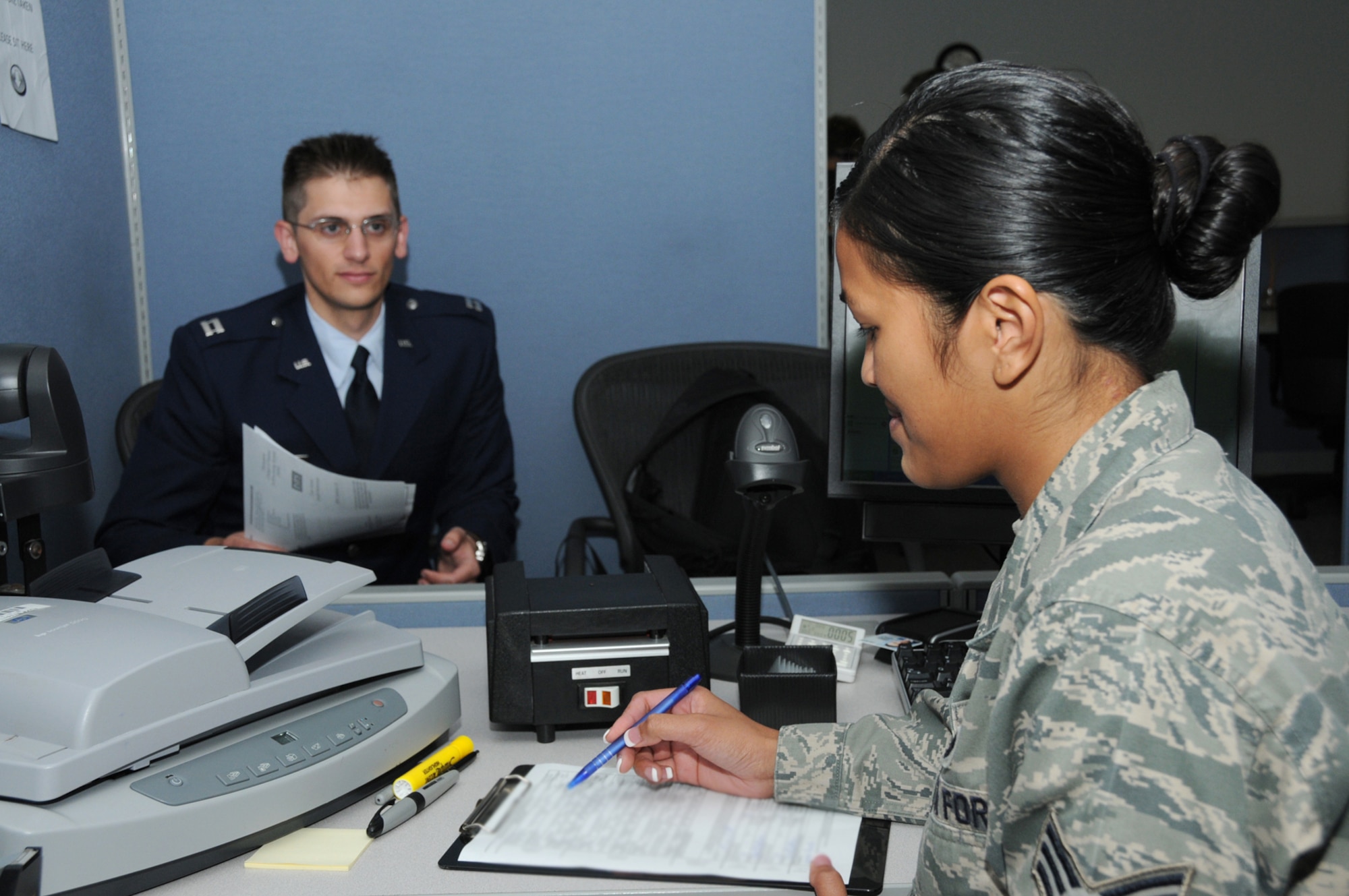 Capt. Robert Henley, 81st Aerospace Medicine Squadron, is provided with a common access card at the customer service office in Sablich Center by Senior Airman Monik Oubina.  (U.S. Air Force photo by Kemberly Groue)