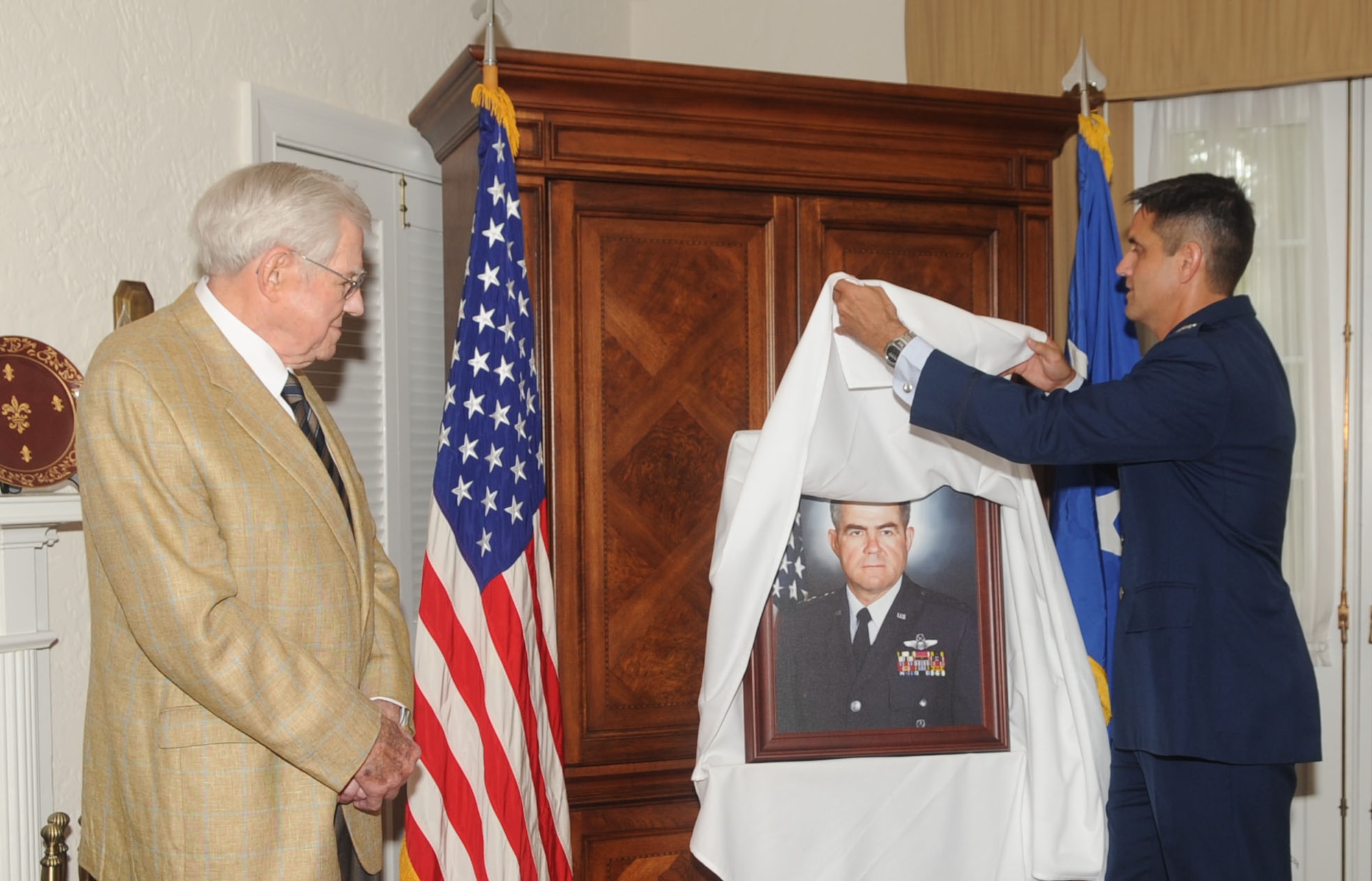 BARKSDALE AIR FORCE BASE, La. – Col. Steven Basham, 2d Bomb Wing commander unveils a canvas portrait of Lt. Gen. Edgar Harris, Jr., former Eighth Air Force commander, during a dedication ceremony at the Harris House July 14. The canvas will be placed above the mantel located in the family room of the house. (U.S. Air Force photo by Senior Airman Alexandra M. Boutte) (RELEASED)