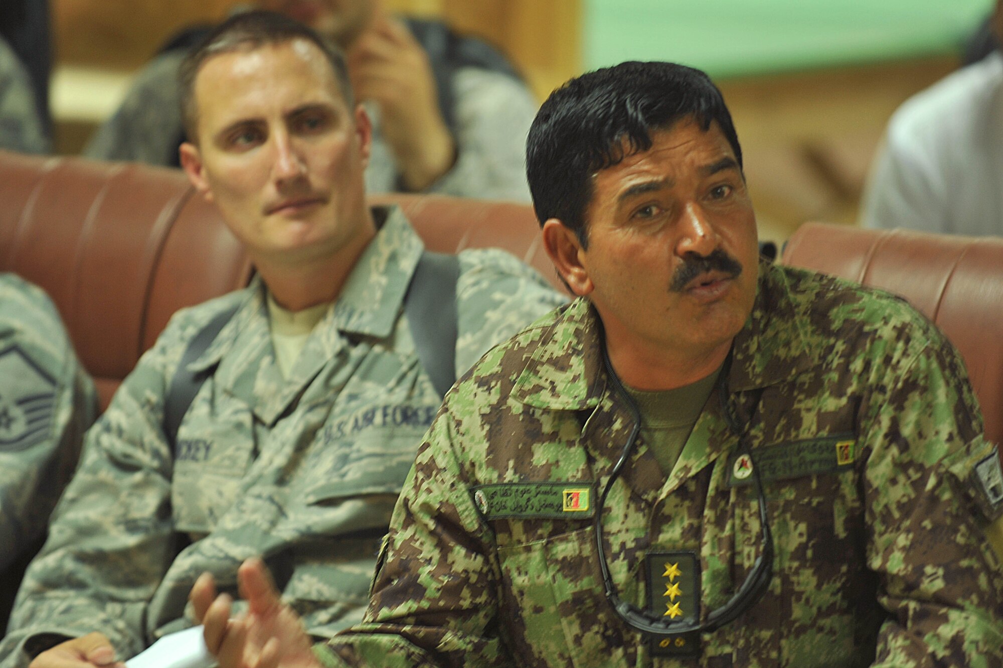 An Afghan Air Force member listens to U.S. Air Force personnel of the 738th Air Expeditionary Advisory Group conduct a mishap safety briefing for a command post exercise at Kandahar Airfield July 7, 2010.  The briefing was a table top meeting with members of the Afghan Air Force and advisors from the 738 AEAG prior to a downed aircraft exercise that will be held at Kandahar Airfield, Afghanistan.  (U.S. Air Force photo/Staff Sgt. Quinton Russ/released)