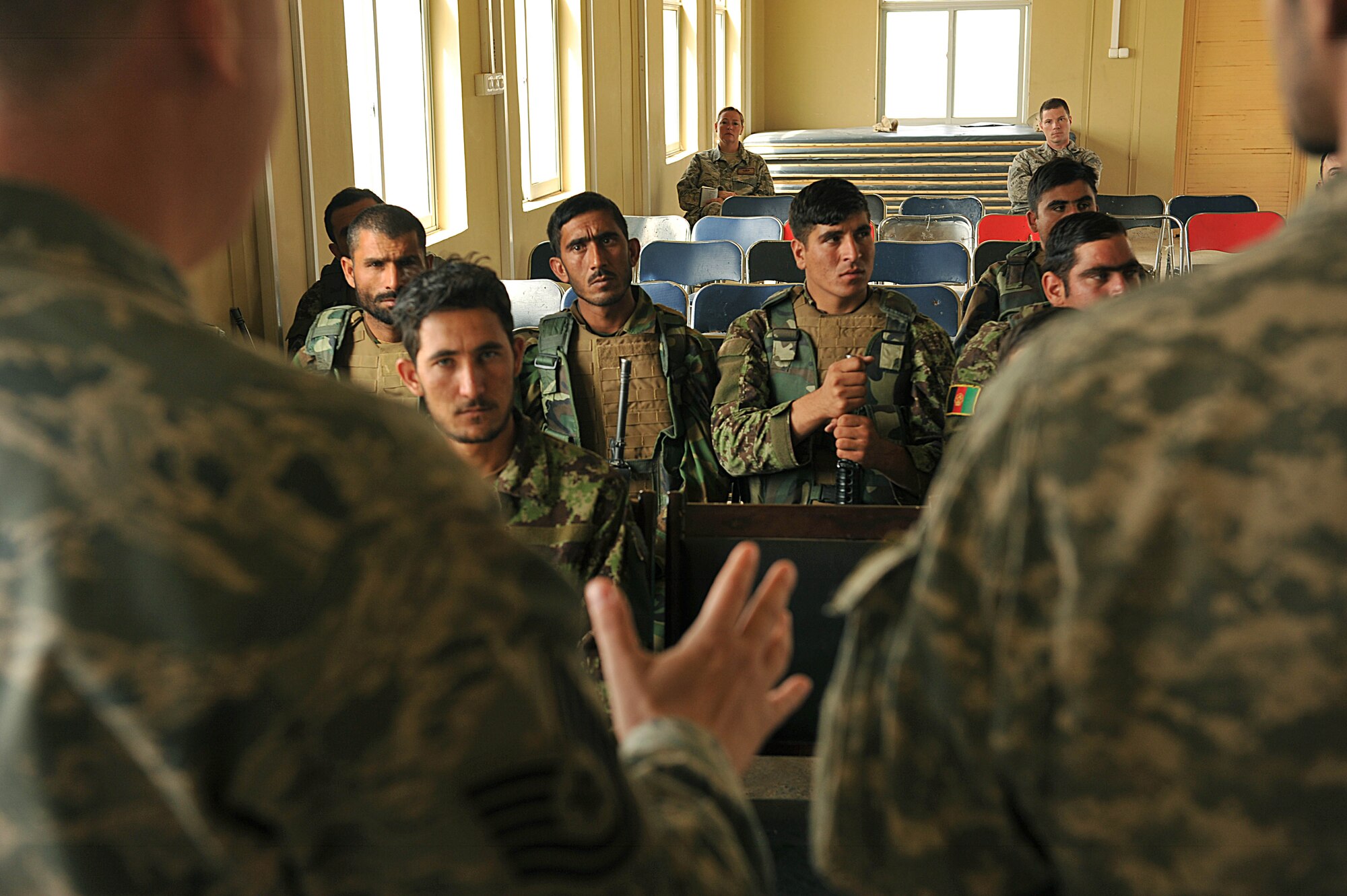 Afghan Air Force members listen as U.S. Air Force Tech. Sgt. Michael Smith teaches a class on entry control points and vehicle searches for explosive devices at Kandahar Airfield, Afghanistan, June 30, 2010.  The training prepares the Afghan security forces for realistic events they may encounter while in the field.  Sergeant Smith is a security forces advisor deployed to the 738th Air Expeditionary Advisory Group.  (U.S. Air Force photo/Staff Sgt. Quinton Russ/released)