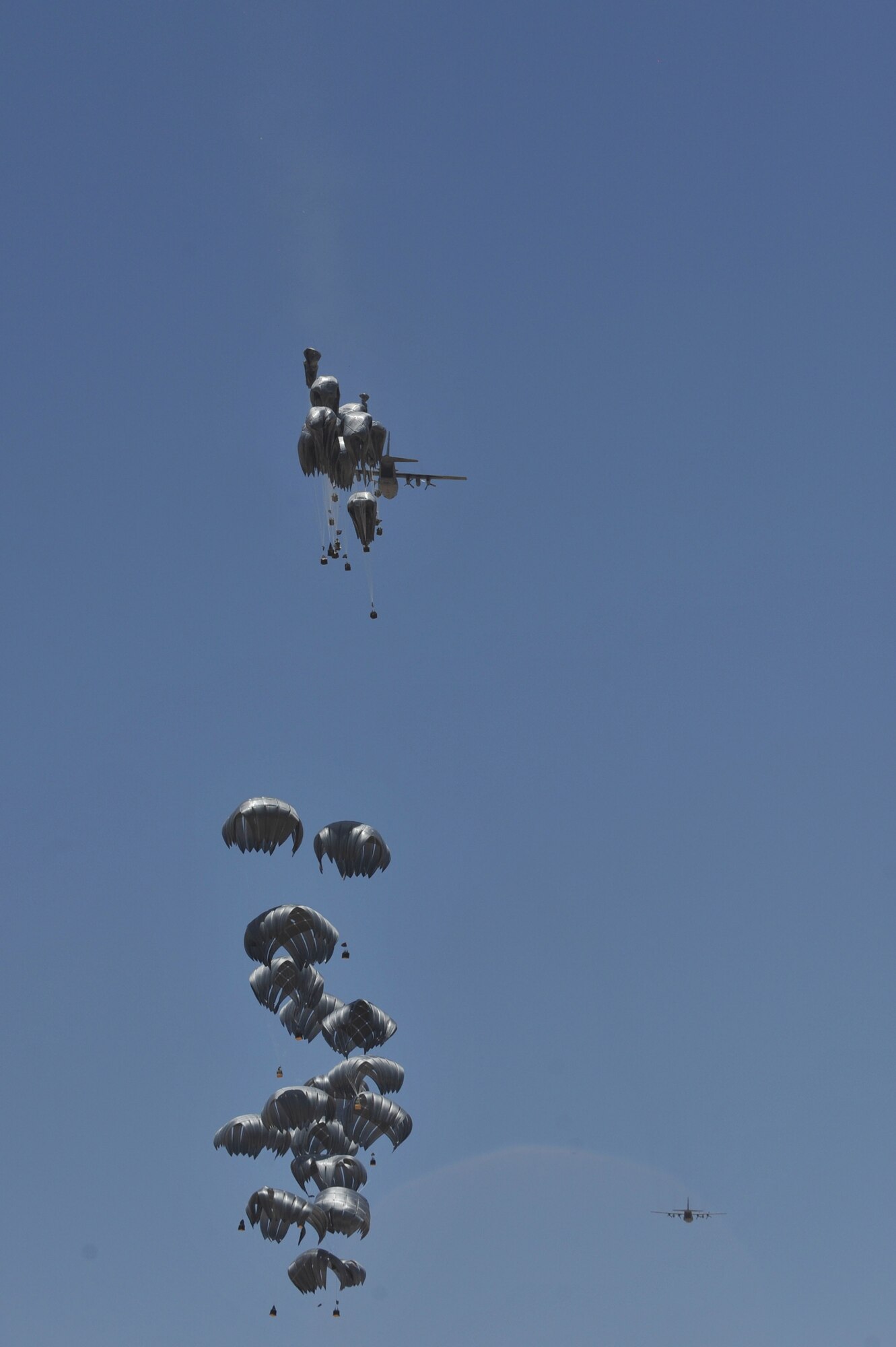 A C-130 Hercules airdrops supplies to troops at forward operating base Tycz, Afghanistan June 29, 2010. The 738th Air Expeditionary Advisory Group conducted Mi-17 missions in the area and is responsible for training and mentoring the Afghanistan National Army Air Force. (U.S. Air Force photo/Staff Sgt. Quinton Russ/released)