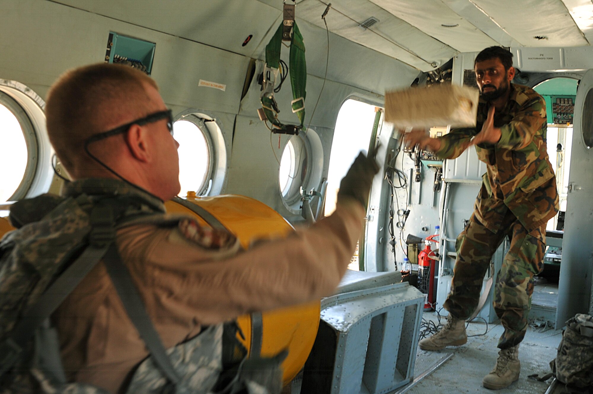 U.S. Air Force Tech. Sgt. Robert Anderson helps an Afghan airman unload supplies off an Mi-17 helicopter during a troop and supply movement at forward operating base Tinsley, Afghanistan June 29, 2010.  Sergeant Anderson is a maintenance advisor deployed to the 738th Air Expeditionary Advisory Group.  Members of the 738 AEAG are responsible for training and mentoring the Afghanistan National Army Air Force. (U.S. Air Force photo/Staff Sgt. Quinton Russ/released)