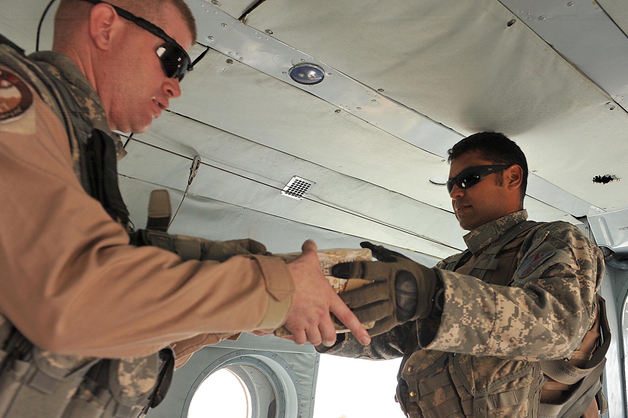 U.S. Air Force Tech. Sgt. Robert Anderson and Army Sgt. 1st Class David Lara load supplies onto an Mi-17 helicopter during a troop and supply movement at Tereen-Kowt, Afghanistan, June 29, 2010.  Sergeant Anderson is a maintenance advisor and Sergeant Lara is a flight medic deployed to the 738th Air Expeditionary Advisory Group.  Members of the 738 AEAG are responsible for training and mentoring the Afghanistan National Army Air Force. (U.S. Air Force photo/Staff Sgt. Quinton Russ/released)
