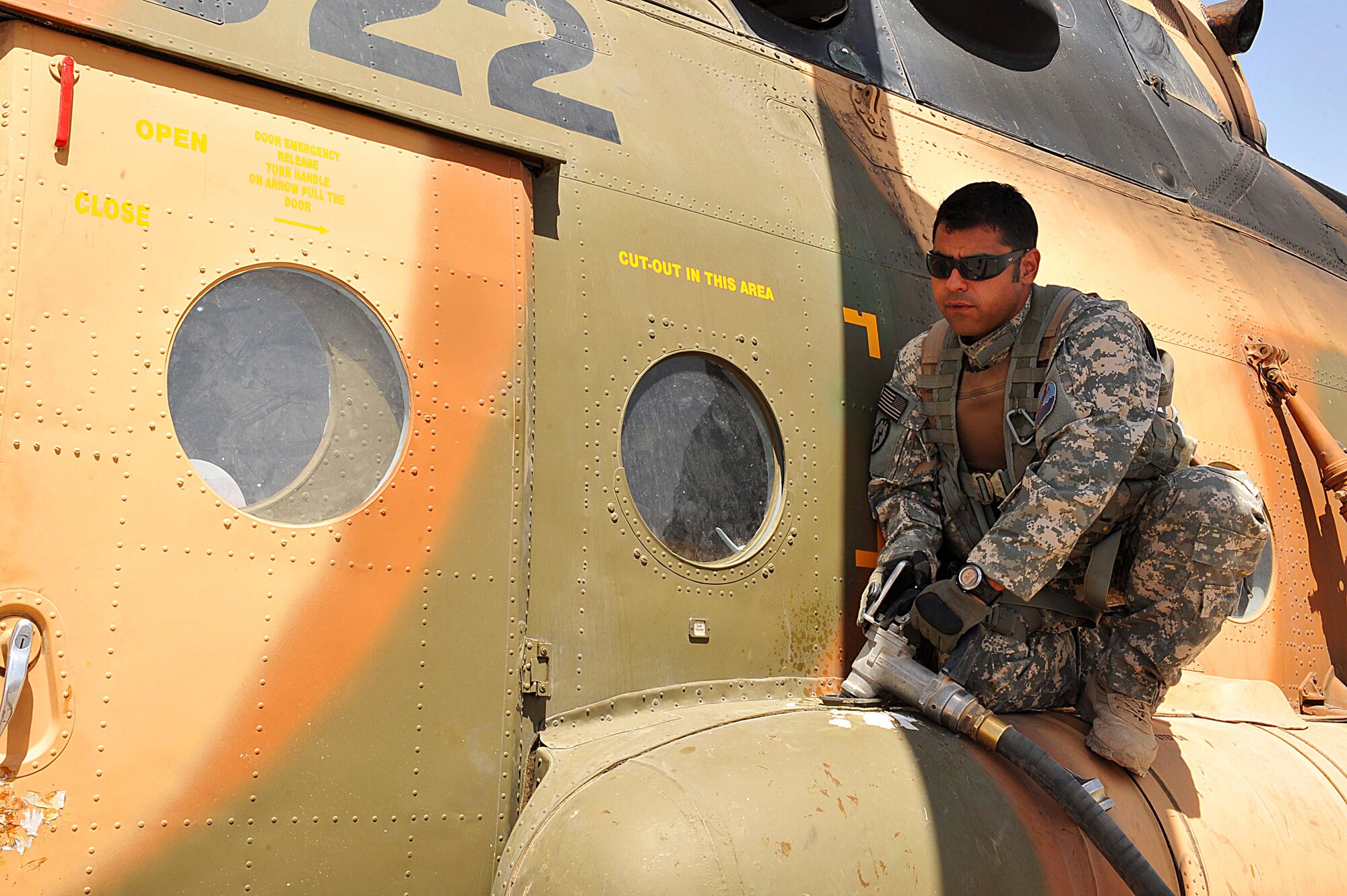 U.S. Army Sgt. 1st. Class David Lara refuels an Mi-17 helicopter during a troop and supply movement at Tereen-Kowt, Afghanistan June 29, 2010.  Sergeant Lara is a flight medic deployed to the 738th Air Expeditionary Advisory Group.  Members of the 738 AEAG are responsible for training and mentoring the Afghanistan National Army Air Force. (U.S. Air Force photo/Staff Sgt. Quinton Russ/released)