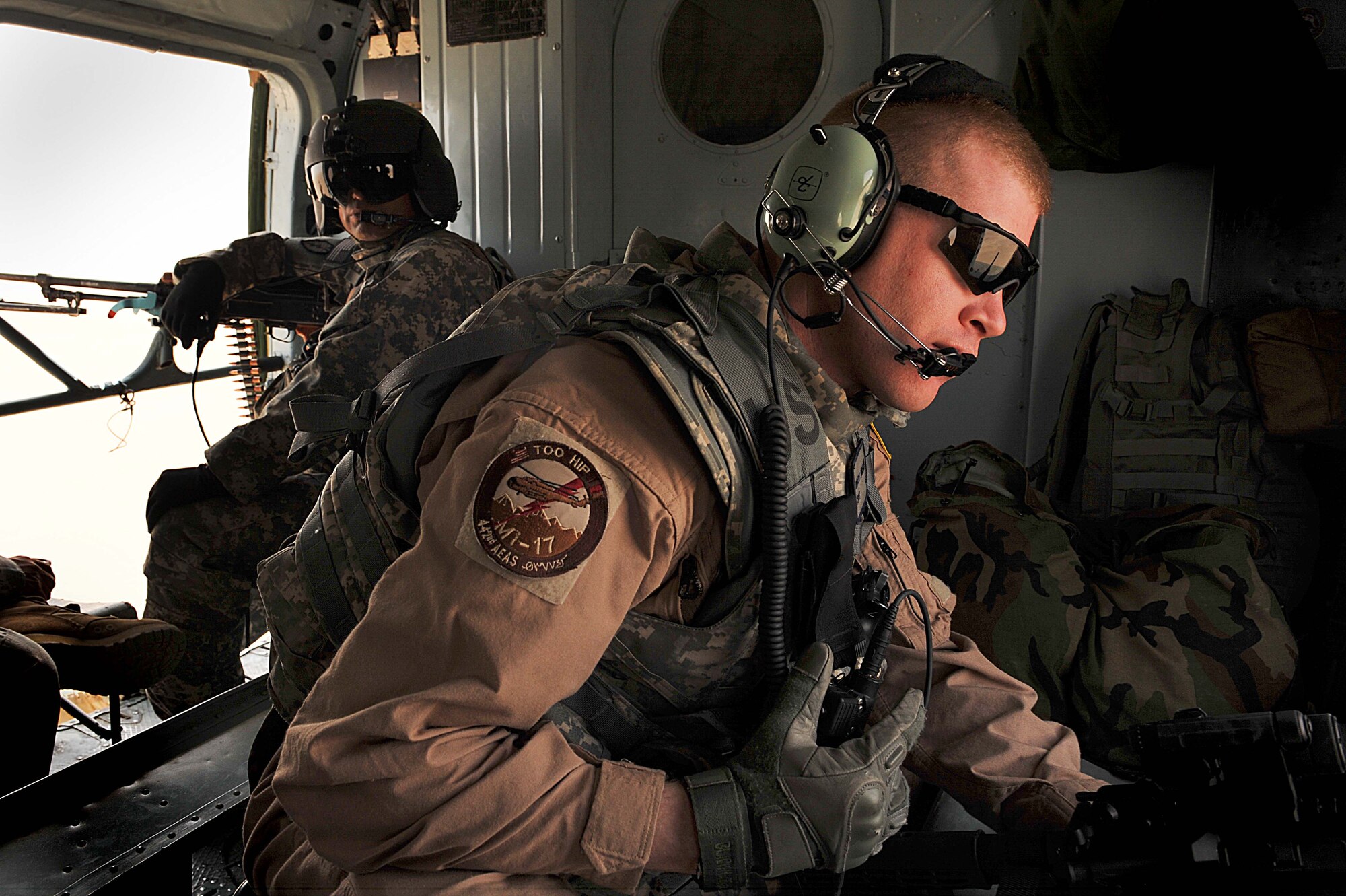 U.S. Air Force Tech. Sgt. Robert Anderson, foreground, and Army Sgt. 1st Class David Lara, background, scan their areas in an Mi-17 helicopter over Afghanistan June 29, 2010.  Sergeant Anderson is a maintenance advisor and Sergeant Lara is a flight medic deployed to the 738th Air Expeditionary Advisory Group.  Members of the 738 AEAG are responsible for training and mentoring the Afghanistan National Army Air Force. (U.S. Air Force photo/Staff Sgt. Quinton Russ/released)