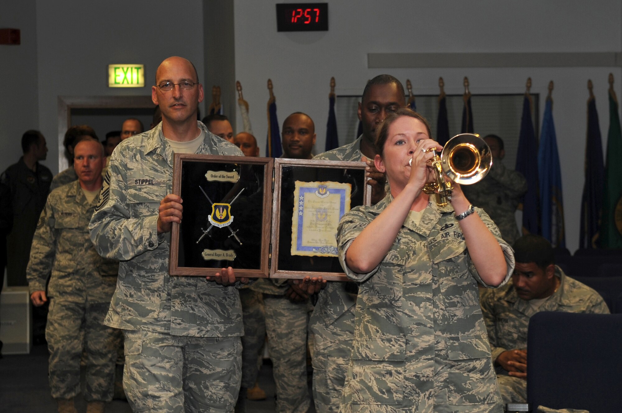 Staff Sgt. Brenna Dooley, U.S. Air Forces in Europe Band journeyman, plays the trumpet as a surprise to Gen. Roger A. Brady, USAFE commander, before USAFE enlisted members present him with an Order of the Sword invitation at the Kisling NCO Academy on Kapaun Air Station, Germany, July 14, 2010. General Brady will formally accept the honor during a ceremony in the fall at Ramstein Air Base, Germany. (U.S. Air Force photo by Airman 1st Class Grovert Fuentes-Contreras)