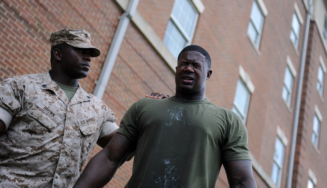 Lance Cpl. Brandon Davis, a body bearer from Marine Barracks Washington, tries to open his eyes after  being sprayed with Oleoresin Capsicum (OC) spray at Marine Barracks Washington July 15. Marines completed the OC spray to recieve their Level 1 certification. (Photo by Cpl. Bobby J. Yarbrough)