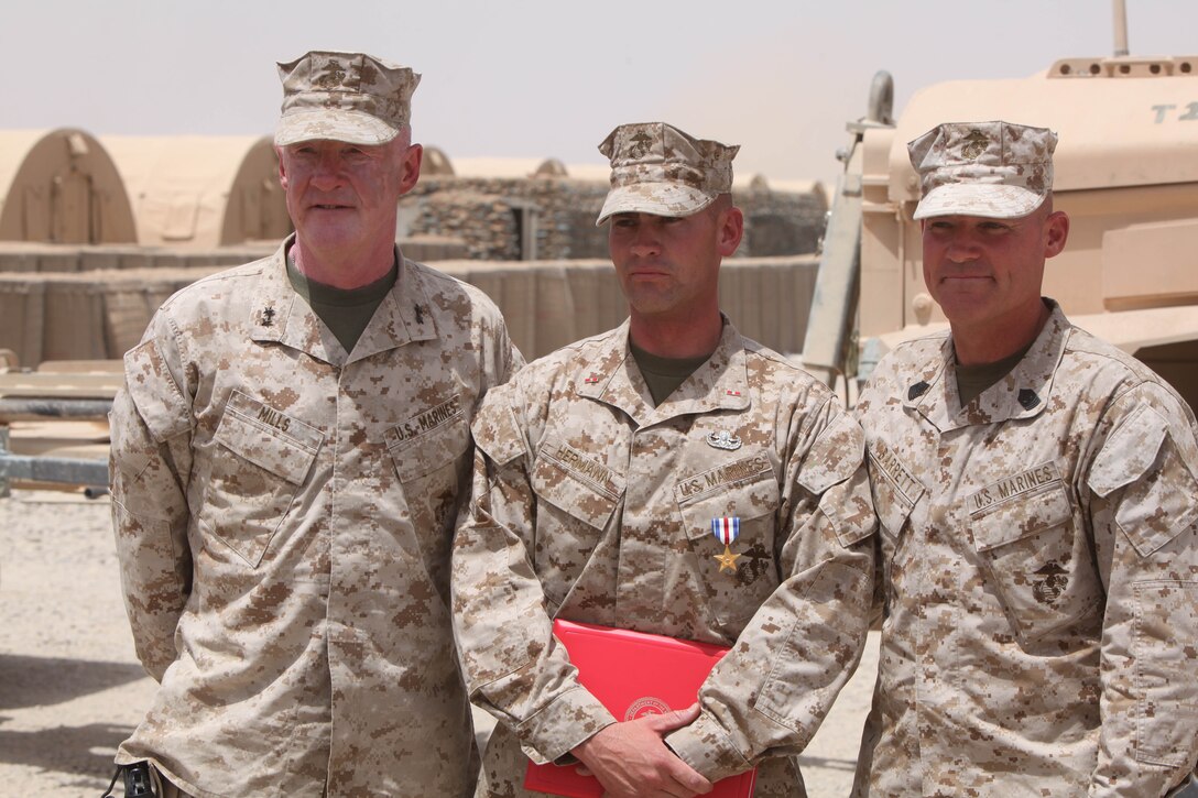 Warrant Officer John Hermann (center), 32, from Tucson, Ariz., explosive ordnance disposal officer for 1st Explosive Ordnance Disposal Company, 1st Marine Logistics Group (Forward), stands with Maj. Gen. Richard Mills (left), commander of Regional Command Southwest, and Sgt. Maj. Michael Barrett (right), sergeant major of RC (SW), after being awarded the Silver Star medal at Camp Delaram II, Helmand Province, Afghanistan, July 15.