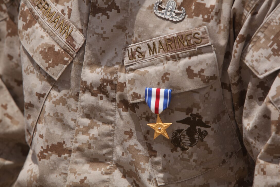 Warrant Officer John Hermann, 32, from Tucson, Ariz., explosive ordnance disposal officer for 1st Explosive Ordnance Disposal Company, 1st Marine Logistics Group (Forward), was awarded the Silver Star medal in a ceremony at Forward Operating Base Delaram II, Helmand Province, Afghanistan, July 15. In February 2008, Hermann was deployed to Afghanistan as an EOD technician when his element came under enemy fire in the village of Dahaneh, Afghanistan. One of his fellow Marines was shot in the leg while running behind him.  Ignoring his own shrapnel wounds from a rocket propelled grenade, Hermann “single-handedly destroyed the enemy assailants, and then crossed back through the machine gun fire of another enemy position in order to treat his fallen comrade,” according to his Silver Star citation. He applied a tourniquet to the wounded Marine’s leg, then took charge of the Marines to establish a security cordon and evacuate the Marine to safety. Hermann was later promoted to gunnery sergeant and then selected for the warrant officer program. He has served in the Marine Corps 14 years.