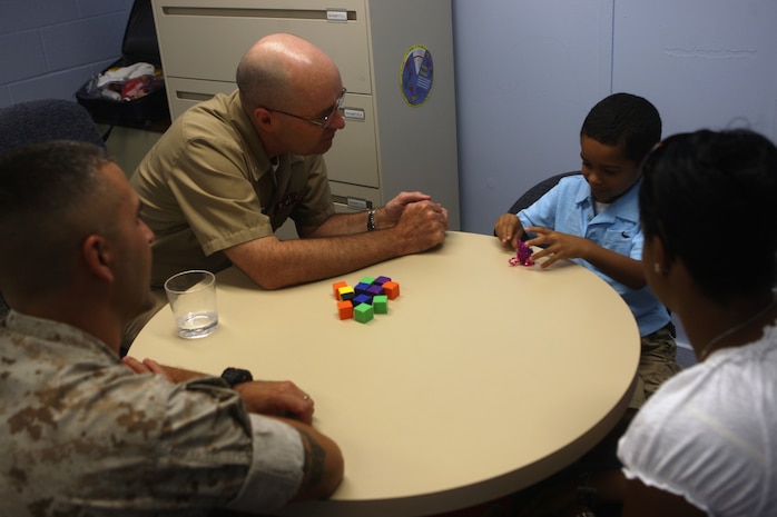 Navy Capt. Joseph McBreen, medical consultant for the Marine Corps Base Camp Lejeune Educational and Developmental Intervention Services, sits down with a family at the Berkeley Manor Naval Hospital Annex, recently. The EDIS program, following the Exceptional Family Member Program, assists family members in diagnosing their childrens' possible handicap while also providing treatment and any medicine that may be necessary at no expense to the family.