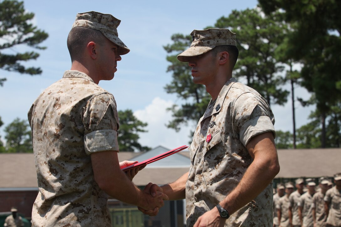 Lt. Col. Todd R. Finley, commanding officer of 3rd Battalion, 10th Marine regiment, shakes hand with Petty Officer 3rd Class Nicholas C. Latham after just awarding him the Bronze Star medal with combat distinguishing device.