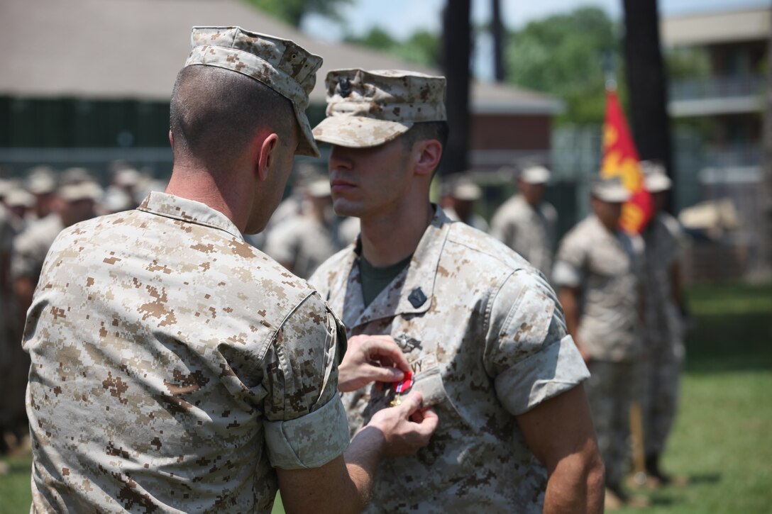 Lt. Col. Todd R. Finley, commanding officer of 3rd Battalion, 10th Marine regiment, shakes hand with Petty Officer 3rd Class Nicholas C. Latham after just awarding him the Bronze Star medal with combat distinguishing device.