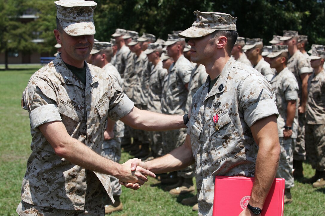 Lt. Col. Todd R. Finley, commanding officer of 3rd Battalion, 10th Marine regiment, shakes hand with Petty Officer 3rd Class Nicholas C. Latham after just awarding him the Bronze Star medal with combat distinguishing device.