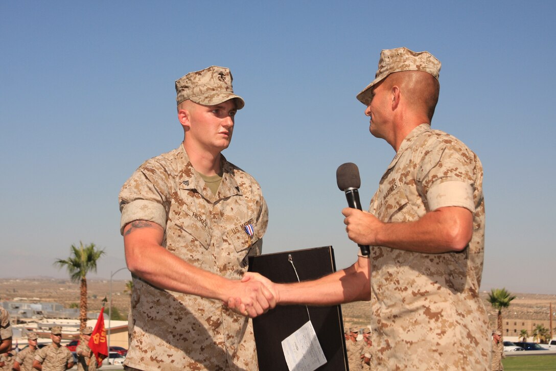 Corporal Daniel Hickey, a team leader with 2nd Battalion, 7th Marine Regiment, Shakes hands with Lt. Col. John M. Reed, his battalion commander, after receiving the Silver Star during an awards ceremony at Lance Cpl. Torrey Gray Field July 16.