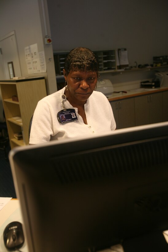 Cherly A. King, a Security technician with pass and I.D., works on getting information put into the computer for a guest of Cherry Points, July 16.