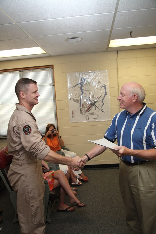 Lt. Col. John A. Rahe receives a certificate declaring his 3,000 flight hours in the AV-8B Harrier from retired Col. Charlie Davis during a ceremony in Marine Attack Training Squadron 203’s ready room July 16. Rahe, the commanding officer for VMAT-203; and Davis, the deputy program manager for fleet support at Boeing, have both logged more than 3,000 hours in the Harrier.
