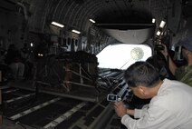 Burt Lum photographs an air drop in a C-17 Globemaster III July, 16, 2010 over a simulated forward operating base in Hawaii. Mr. Lum is a social media from Hawaii Public Radio. (U.S. Air Force photo/Tech. Sgt. Matthew McGovern)