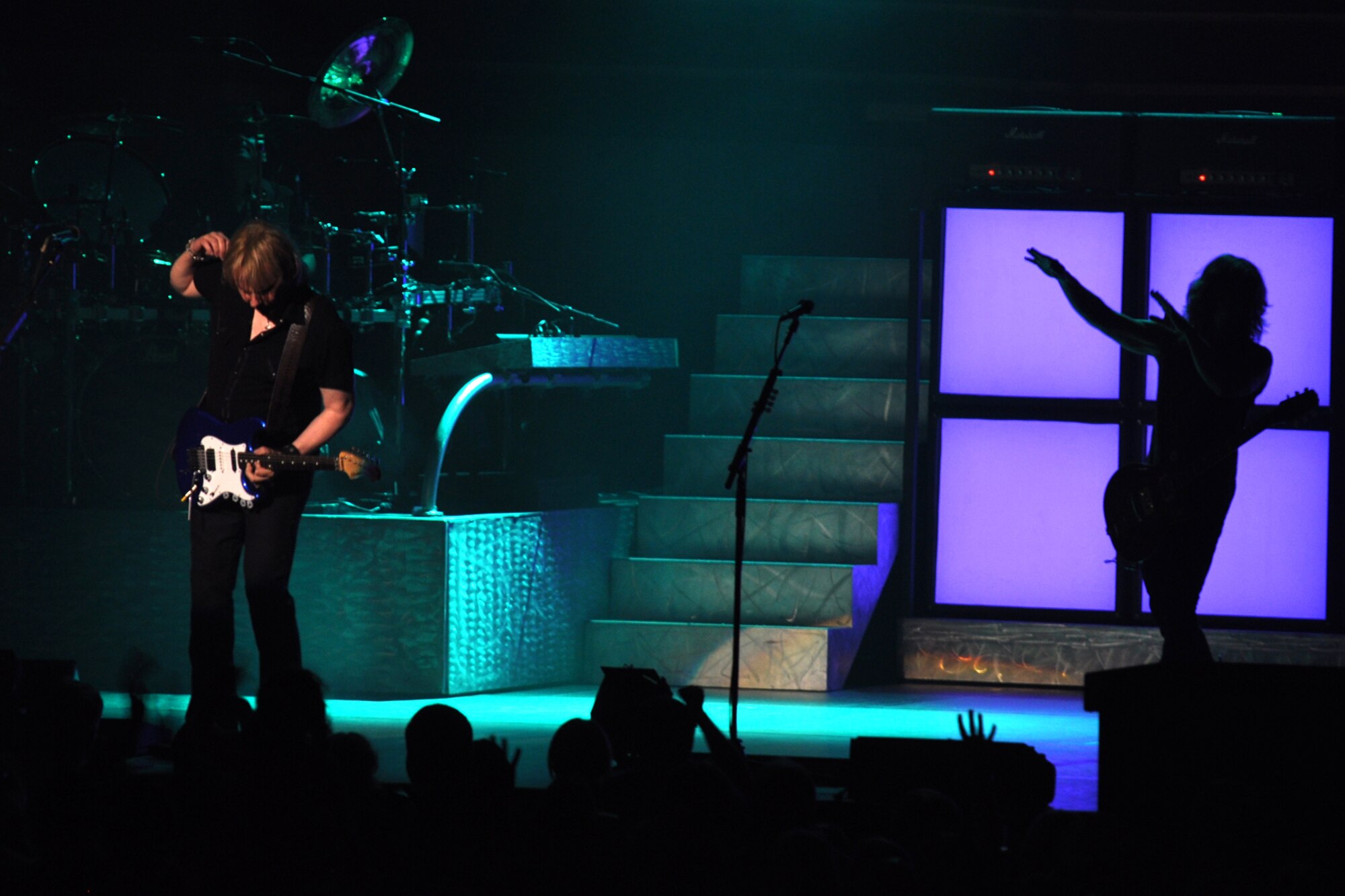 James Young, of the legendary rock band, Styx, strums his guitar as fellow band member Tommy Shaw waits in the shadows during an encore at the CenturyTel Arena, Bossier City, La., July 4, 2010. To celebrate Independence Day and honor the men and women serving our nation at home and overseas, the Air Force Reserve Command sponsored a free concert for any member of the Armed Forces and their immediate families. Best known for their chart topping power ballads such as "Renegade," "Blue Collar Man," and "Too Much Time on My Hands," Styx has performed to sold out audiences around the world. Former U.S. Air Force Sergeant Billy Bretherton, star of the hit television show “Billy the Exterminator,” emceed the event. (U.S. Air Force photo/Tech. Sgt. Jeff Walston)
