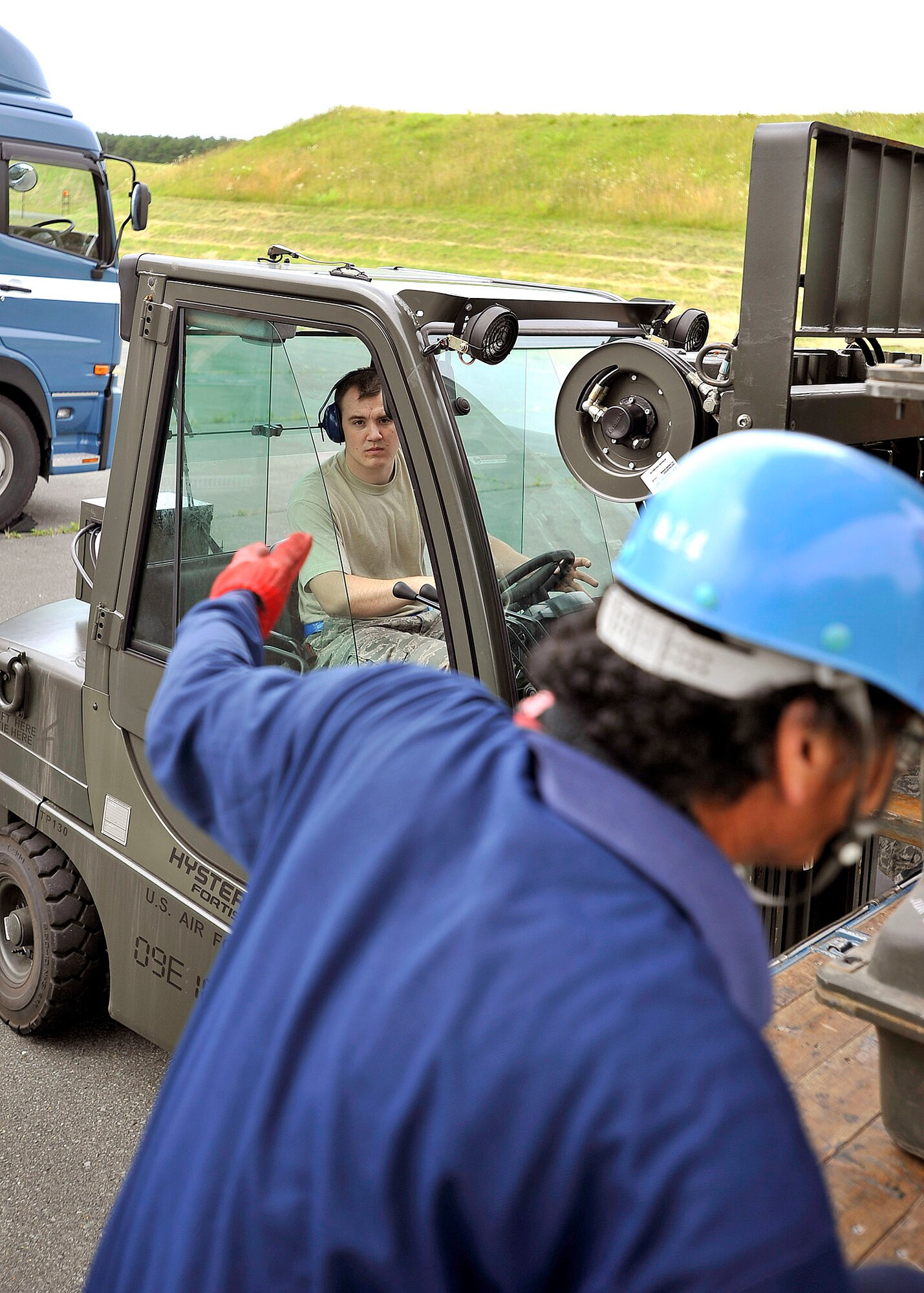 Senior Airman Derek White awaits instruction from a Japanese truck driver while loading munitions July 13, 2010, at Misawa Air Base, Japan.  Airmen there moved more than 700 tons of munitions in an effort to dispose of unserviceable and unused items.  Airman White is a munitions systems specialist with the 35th Maintenance Squadron.  (U.S. Air Force photo/Staff Sgt. Chad C. Strohmeyer)