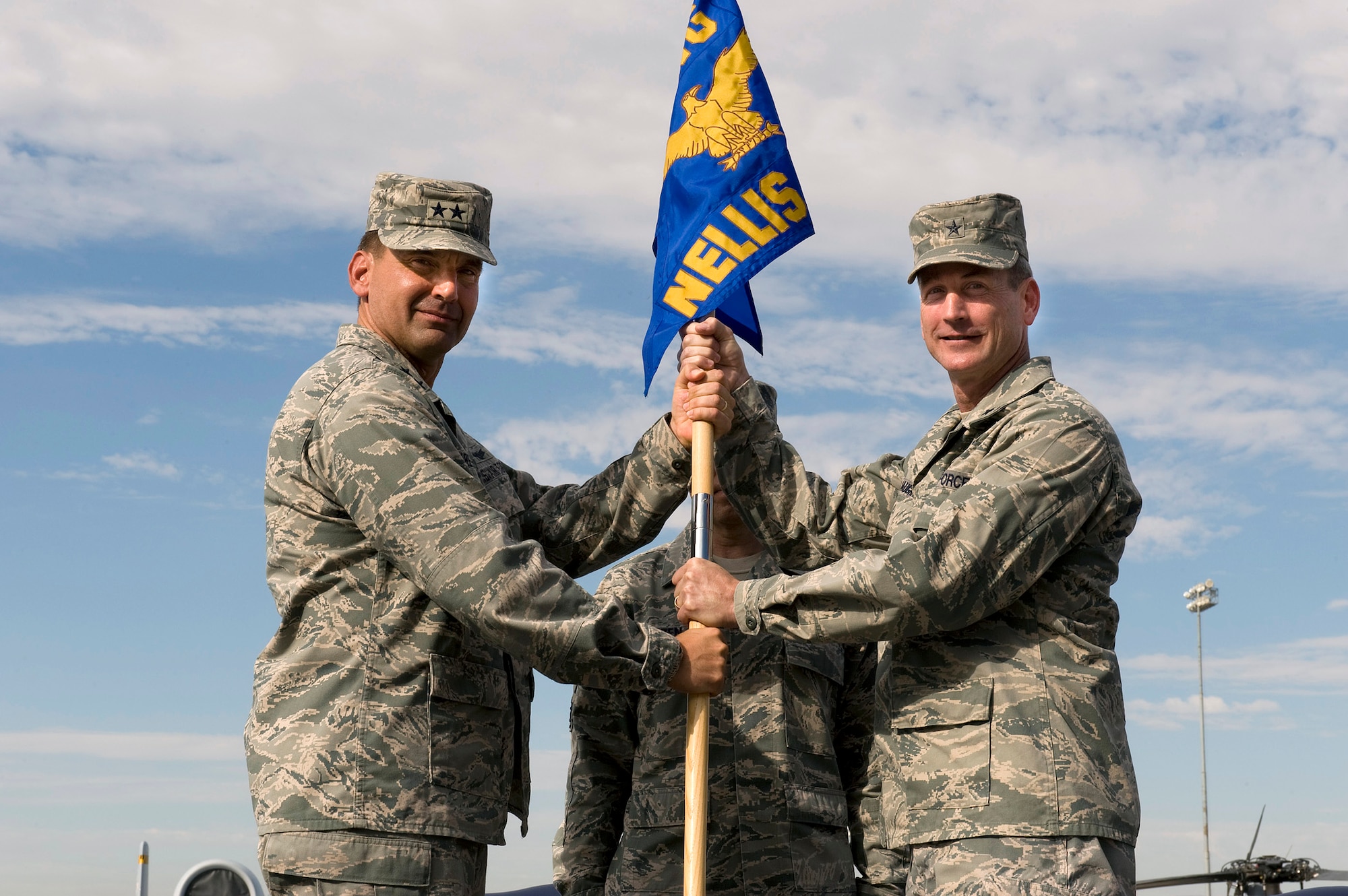 NELLIS AIR FORCE BASE, Nev.--  Maj. Gen. Ted Kresge, U.S. Air Force Warfare Center commander, passes the 57th Wing guidon to Brig. Gen. Terrence O'Shaughnessy, the new 57th Wing commander, at a change of command ceremony July 16. The 57th Wing is responsible for 38 squadrons at 12 installations, constituting the Air Force's most diverse flying wing, flying and maintaining more than 130 aircraft. The 57th Wing also oversees the U.S. Air Force Weapons School; U.S. Air Force Air Demonstration Squadron, the Thunderbirds; and the Red Flag and Green Flag exercises. (U.S. Air Force Photo by Airman 1st Class Brett Clashman)