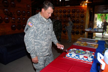 SOTO CANO AIR BASE, Honduras --  Making the first slice in the welcome cake, Lt. Col. Craig Gendreau, the new Army Forces commander here, kicks off the reception after the change of command ceremony here July 16. Colonel Gendreau holds a bachelor's degree in criminal justice and a master's degree in management. (U.S. Air Force photo/Martin Chahin)