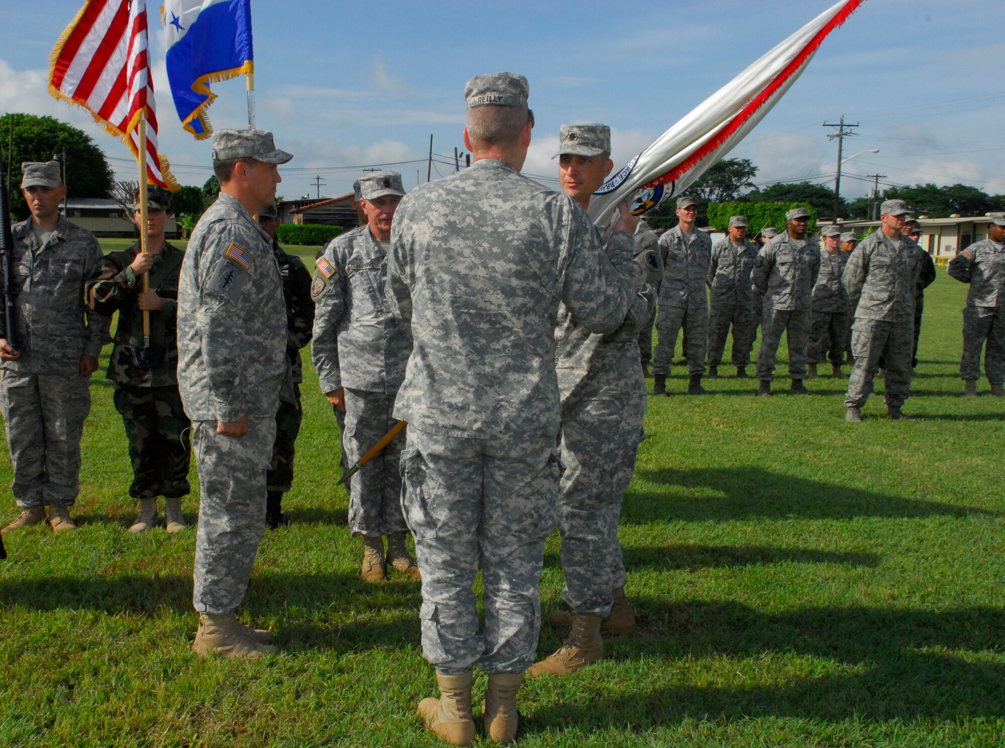 SOTO CANO AIR BASE, Honduras -- As he relinquishes command of Army Forces here, Lt. Col. Curtis Anderson II hands the ARFOR guidon to Col. Gregory Reilly, the Joint Task Force-Bravo commander, during the change of command ceremony here July 16. Colonel Anderson's next assignment is with the Human Resources Command at Fort Knox, Ky. (U.S. Air Force photo/Martin Chahin)