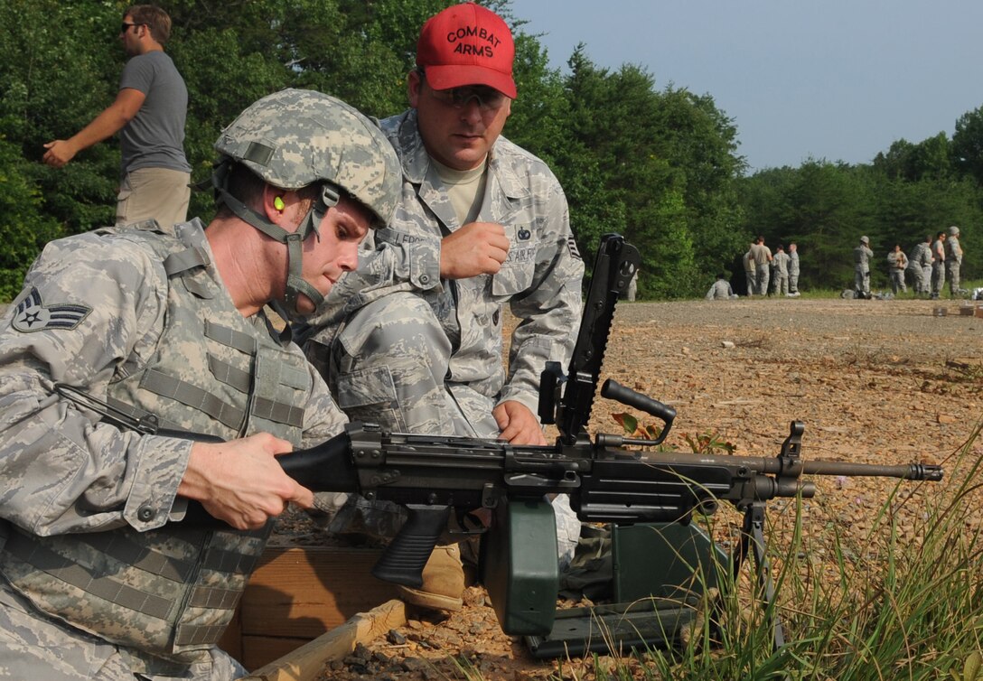 Staff Sgt. John Lepore, 316th Security Forces Squadron patrolman, shows Senior Airman Michael Jones 316th SFS patrolman, how to clear a M249 light machine gun at Marine Corps Base Quantico, July 15, 2010. 316th SFS combat arms instructors qualify base defenders and forward deploying members as needed on the M249 which fires up to 1,000 rounds per minute at a range of up to 3600 meters. The M249 is one of three fire arms that Andrews Airmen can only quality on at Quantico. (U.S. Air Force photo by Senior Airman Melissa V. Brownstein)