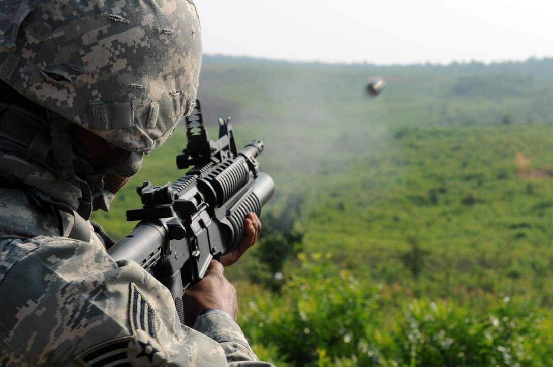 Senior Airman Patrick Garner, 316th Security Forces Squadron patrolman, fires a practice round out of a M203 grenade launcher at Marine Corps Base Quantico, July 15, 2010.  316th SFS combat arms instructors qualify base defenders and forward deploying members as needed on the M203 using practice rounds that that fire up to 400 meters. (U.S. Air Force photo by Senior Airman Melissa V. Brownstein)