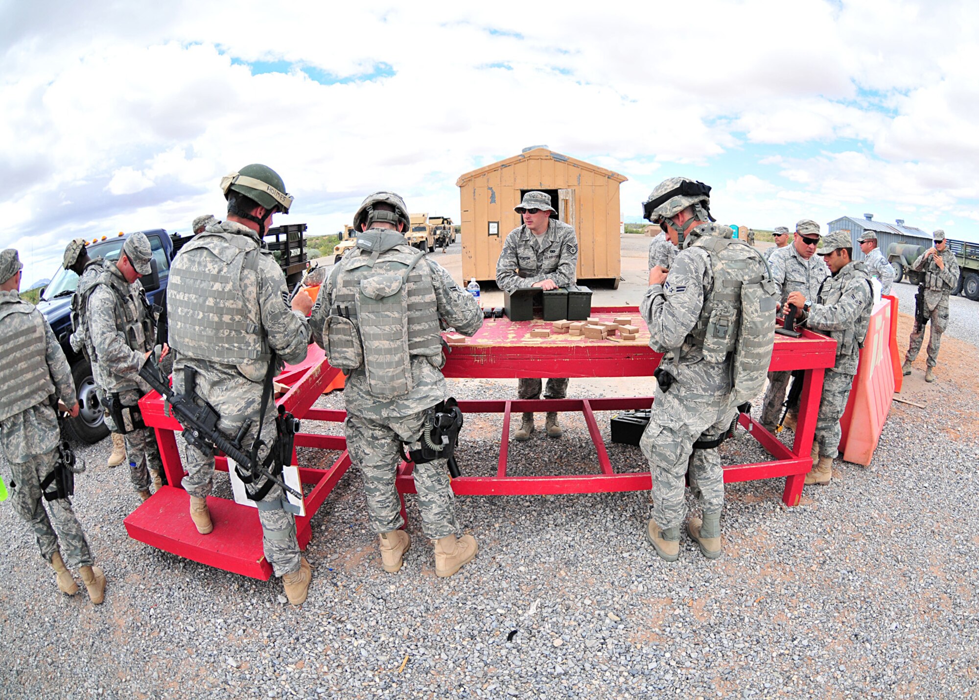 Arming under the gaze of instructors, a team of Airmen prepare for a convoy live fire exercise during the U.S. Air Force's Desert Defender area security operations course on Fort Bliss, Texas June 30, 2010. The six-week course is run by the Texas Air National Guard's 204th Security Forces Squadron. It prepares Air Force security forces for area security operations in Iraq and Afghanistan. Airmen deploy after graduation. 