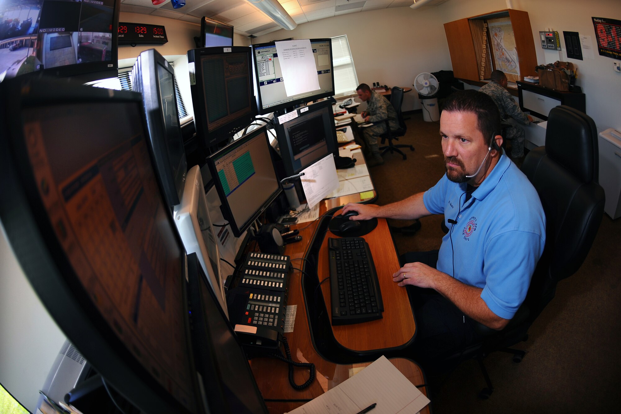 OFFUTT AIR FORCE BASE, Neb. - Dean Moore, a Dispatch Supervisor with the 55th Wing Fire Department, takes a variety of calls while manning one of the phones in the new Emergency Communications Center here July 15.  The ECC was stood up June 29, placing both fire and law enforcement dispatches in a central location to create stronger situational awareness between the two departments. U.S. Air Force photo by Josh Plueger
