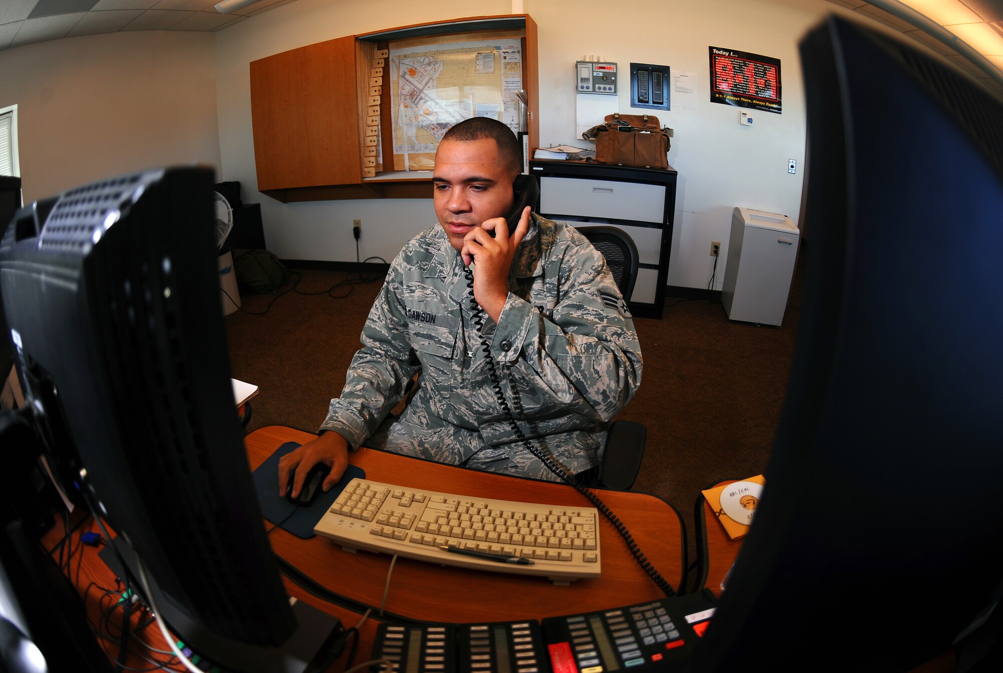 OFFUTT AIR FORCE BASE, NEB ? Senior Airman Josh Dawson, an Emergency Communications Center alarm monitor with the 55th Security Forces Squadron, takes a variety of calls while manning one of the phones in the new Emergency Communications Center here July 15.  The ECC was stood up June 29, placing both fire and law enforcement dispatches in a central location to create stronger situational awareness between the two departments. U.S. Air Force photo by Josh Plueger
