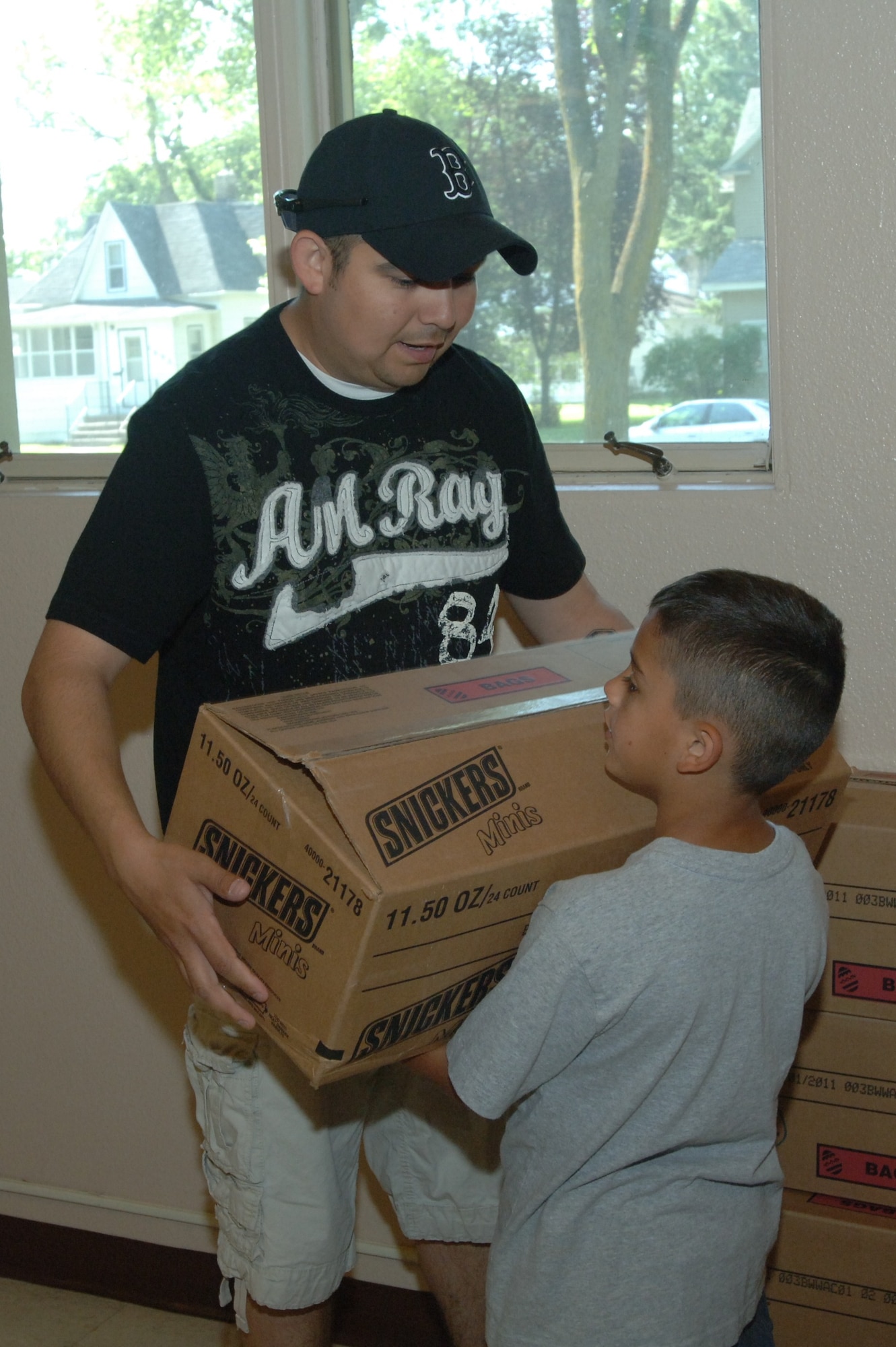 Tech. Sgt. Mark Ochoa, 319th Security Forces Squadron, and his son Anthony help transfer boxes of food for The Salvation Army July 16. The group of Grand Forks Air Force Base volunteers unloaded 10,104 pounds of food worth over $1,200. Network 5/6 organizes volunteers the third Friday of every month to help unload and stock food for the food bank at the Salvation Army in Grand Forks, N.D.
