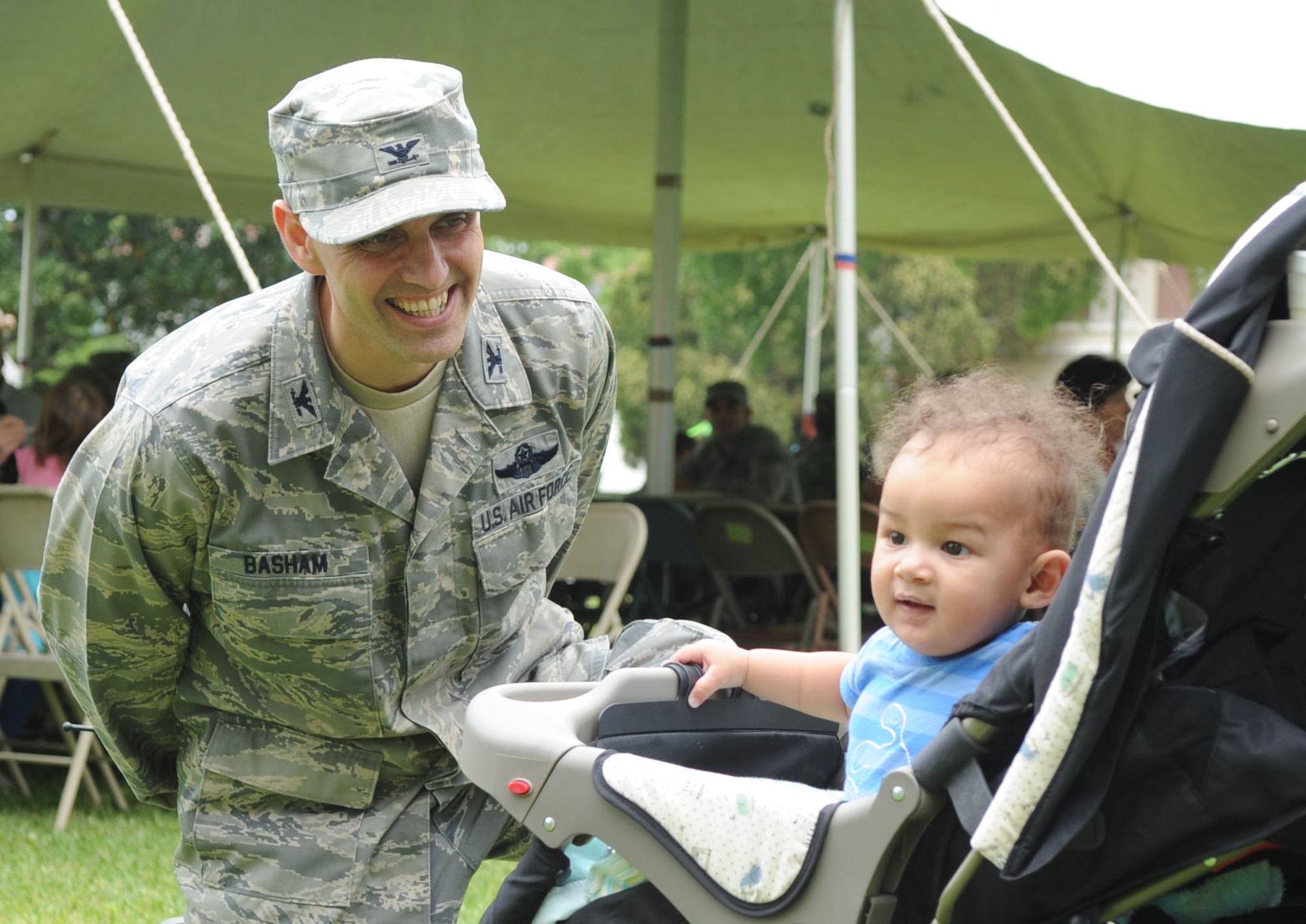 BARKSDALE AIR FORCE BASE, La. -- Col. Steven Basham, 2d Bomb Wing commander, kneels down to Justin Smith, 7 months, and tries to get his attention during the Lunch Before You Launch event at Chapel 1, April 17. (U.S. Air Force photo by Senior Airman Alexandra Boutte)
