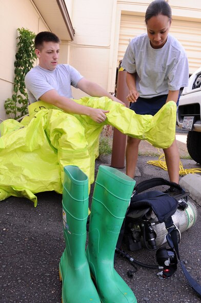 BARKSDALE AIR FORCE BASE, La-- Senior Airman Kristen Thornton, 2d Civil Engineer Squadron emergency management, helps Staff Sgt. James McGarvey, 2d Civil Engineer Squadron emergency management, into his hazardous material suit for the chemical, biological, radiological, nuclear and high-yield explosives, or CBRNE, challenge. The exercise trained bioenvironmental and emergency management teams on overall response to hazardous incidents. (U.S. Air Force photo/Airman 1st Class Allison M. Boehm) (RELEASED)