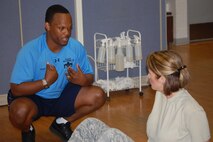 Brandon Johnson, one of the base's fitness assessment cell monitors, talks to Senior Master Sgt. Dana Bates, 916th Aircrew Flight Equipment, about how she can improve her pushups for the new fitness test standards. (USAF photo by Maj. Shannon Mann, 916ARW/PA)