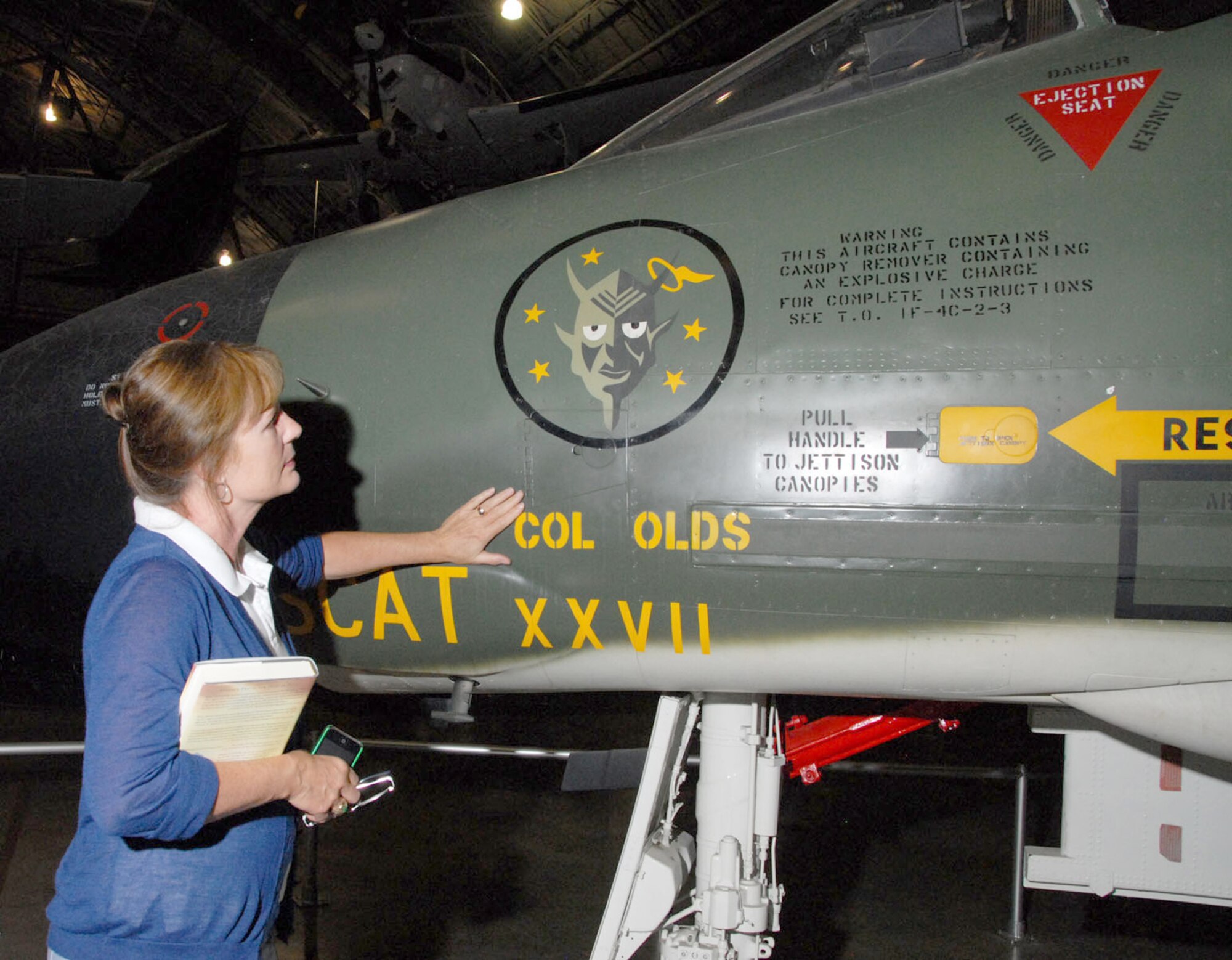 Christina Olds, daughter of the late triple ace and Air Force Cross recipient Brig. Gen. Robin Olds, touches her father's F-4C Phantom II at the National Museum of the U.S. Air Force in Dayton, Ohio. (U.S. Air Force photo)