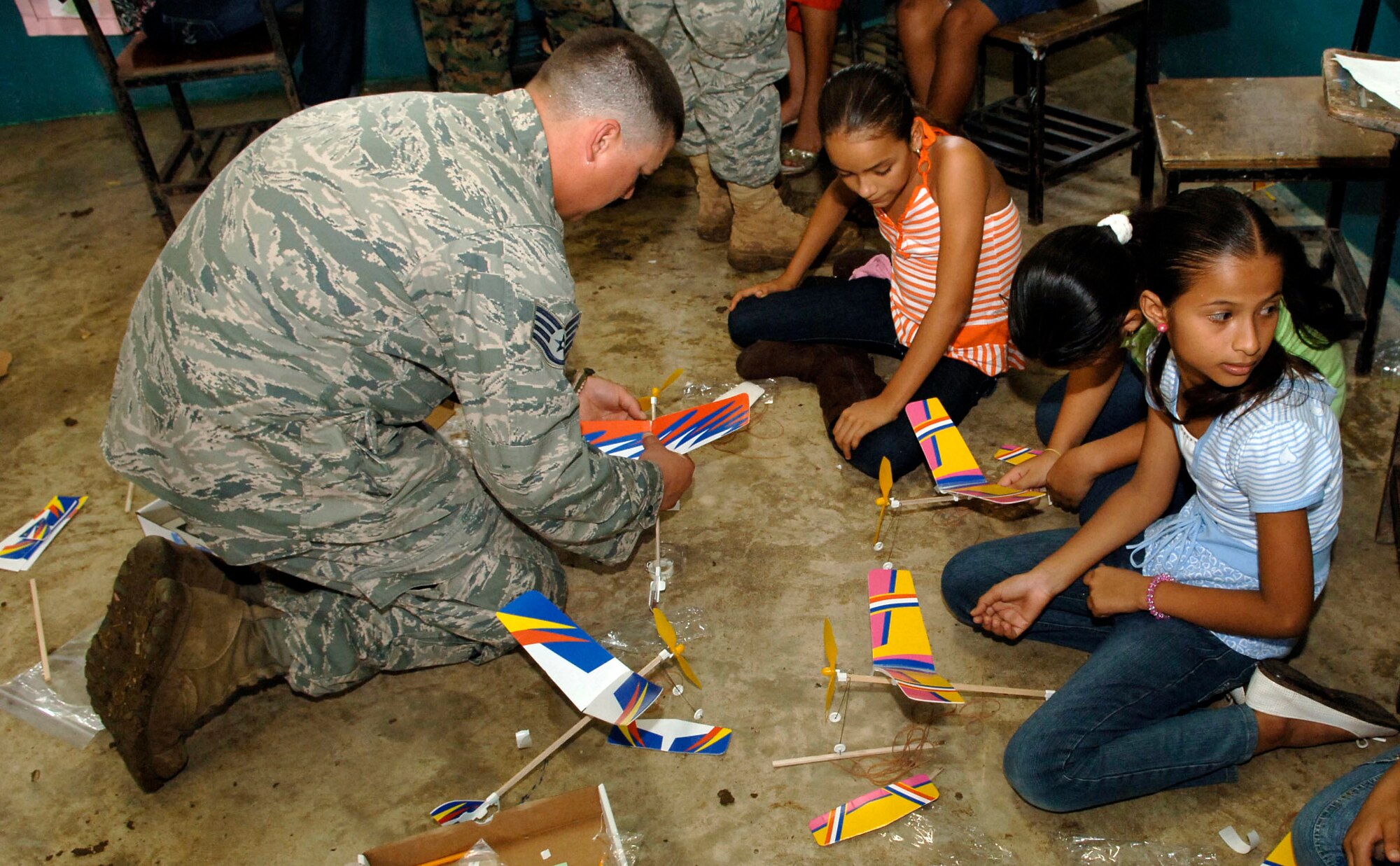 Staff Sgt. Josh Lazarski helps children assemble rubber band airplanes July 12, 2010, at the Sansonsito School in Panama. Sergeant Lazarski is assigned to the 820th Expeditionary RED HORSE Squadron. (U.S. Air Force photo/Tech. Sgt. Eric Petosky)

