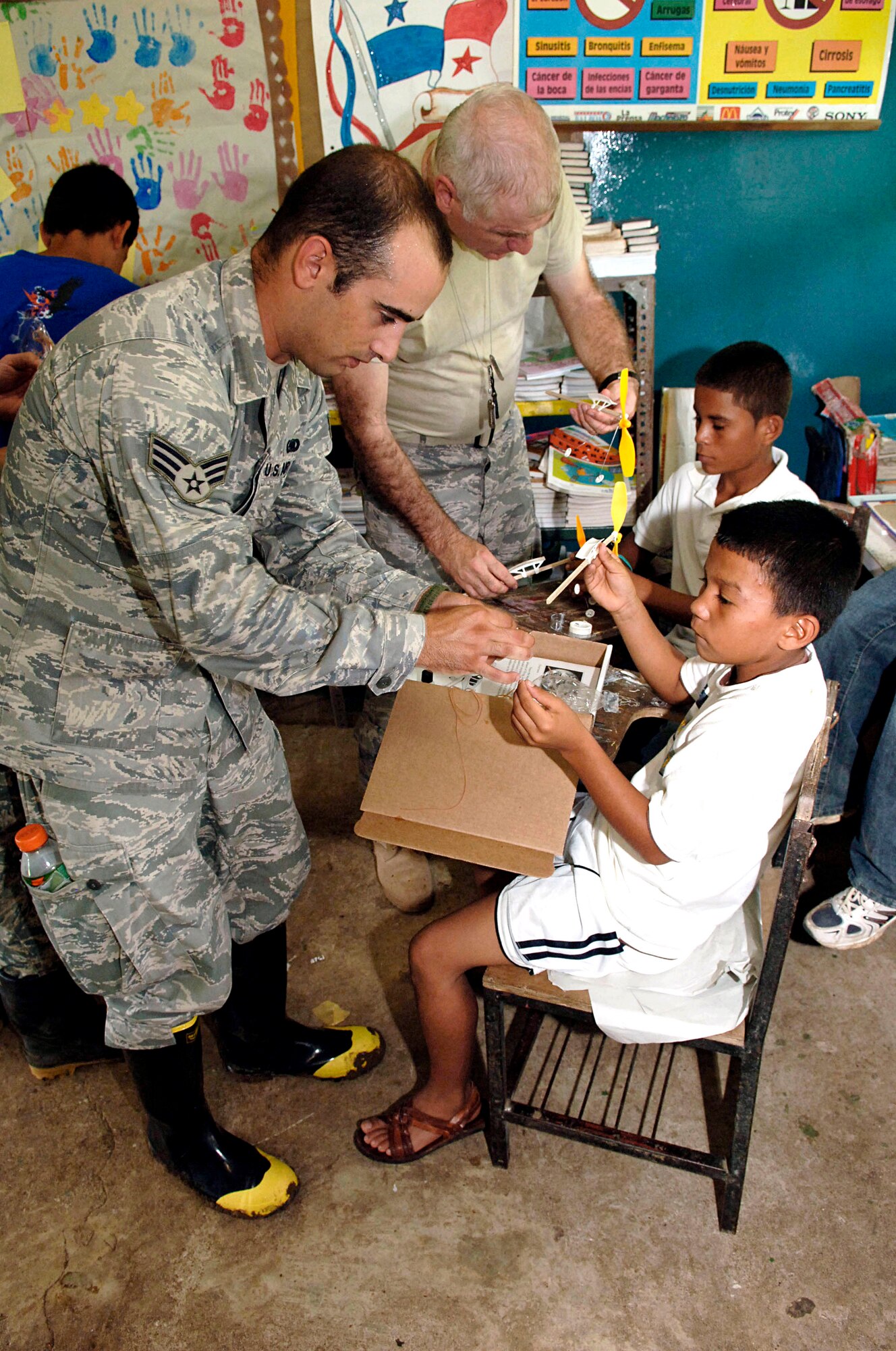 Senior Airman Alex James (left) and Chaplain (Maj.) Norris Burkes help children assemble rubber-band airplanes July 12, 2010, at the Sansonsito School in Panama. Chaplain Burkes and Airman James are assigned to the 820th Expeditionary RED HORSE Squadron. (U.S. Air Force photo/Tech. Sgt. Eric Petosky)
