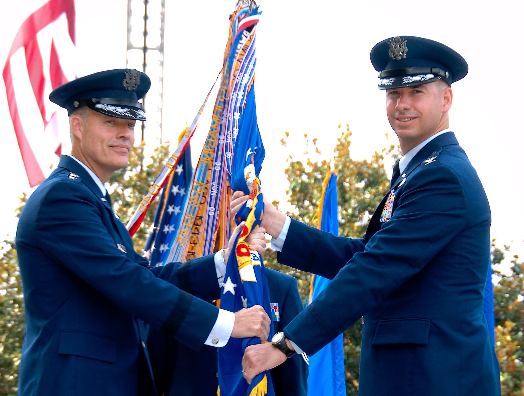 Lt. Gen. Allen Peck (left) passes the guidon to Col. Brian Killough at the 42nd Air Base Wing change of command ceremony Monday. Colonel Killough comes to Maxwell from the Pentagon where he served as deputy director of Headquarters U.S. Air Force’s Capability Based Planning.(U.S. Air Force photo/Donna Burnett)