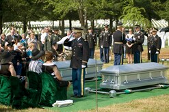 Army Chaplain (Capt.) John Gabriel salutes a folded American flag that was presented to Virginia Doolittle (seated), a surviving family member of 1st Lt. Joseph J. Auld, one of the seven Airmen who were interned July 15, 2010 at Arlington National Cemetery, Va. (DOD photo/Michael Tolzmann)