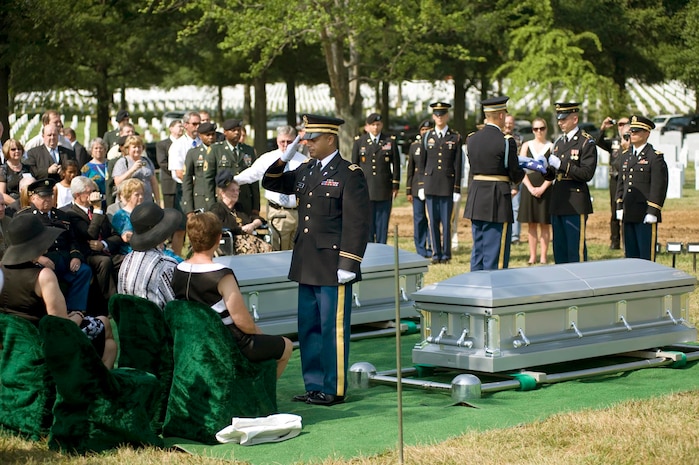 Army Chaplain (Capt.) John Gabriel salutes a folded American flag that was presented to Virginia Doolittle (seated), a surviving family member of 1st Lt. Joseph J. Auld, one of the seven Airmen who were interned July 15, 2010 at Arlington National Cemetery, Va. (DOD photo/Michael Tolzmann)