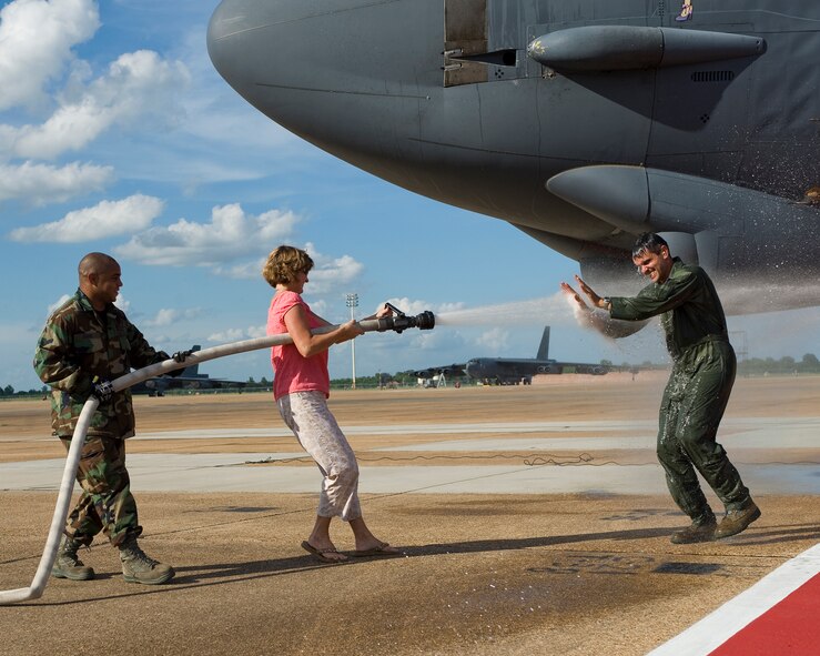 BARKSDALE AIR FORCE BASE, La. -- Angie Basham, wife of 2d Bomb Wing Commander Col. Steven Basham, sprays her husband with a fire hose after his fini-flight July 13. Several of Colonel Basham's family members, friends and fellow Airmen were on hand for his final flight as commander of the 2d BW. (U.S. Air Force photo by Senior Airman Chad Warren)
