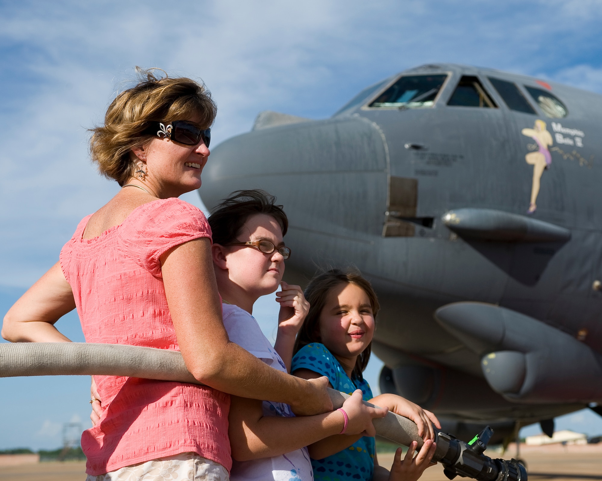 BARKSDALE AIR FORCE BASE, La. -- Angie Basham, wife of 2d Bomb Wing Commander Col. Steven Basham, and their daughters Sarah, 10, and Lauren, 8, wait with a fire hose at the ready during Colonel Basham's fini flight July 13. Several of Colonel Basham's family members, friends and fellow Airmen were on hand for his final flight as commander of the 2 BW. (U.S. Air Force photo by Senior Airman Chad Warren)