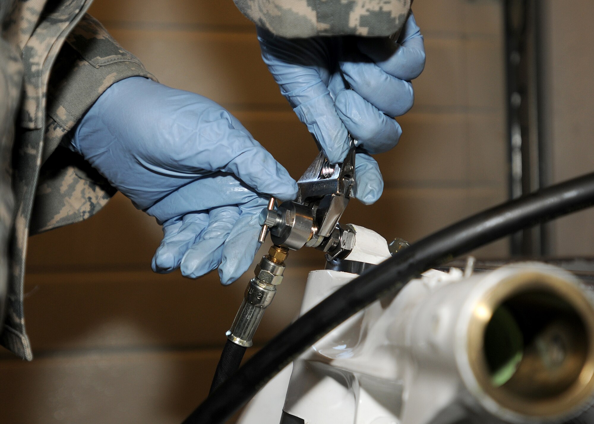 Airman 1st Class Alexander Vergara, 31st Maintenance Squadron hydraulics journeyman, attaches a gauge to an F-16 Fighting Falcon nose landing gear shock strut July 14 at the hydraulics back shop before testing.  The hydraulics back shop is responsible for all hydraulic components of an aircraft.  (U.S. Air Force photo/Senior Airman Tabitha M. Lee)