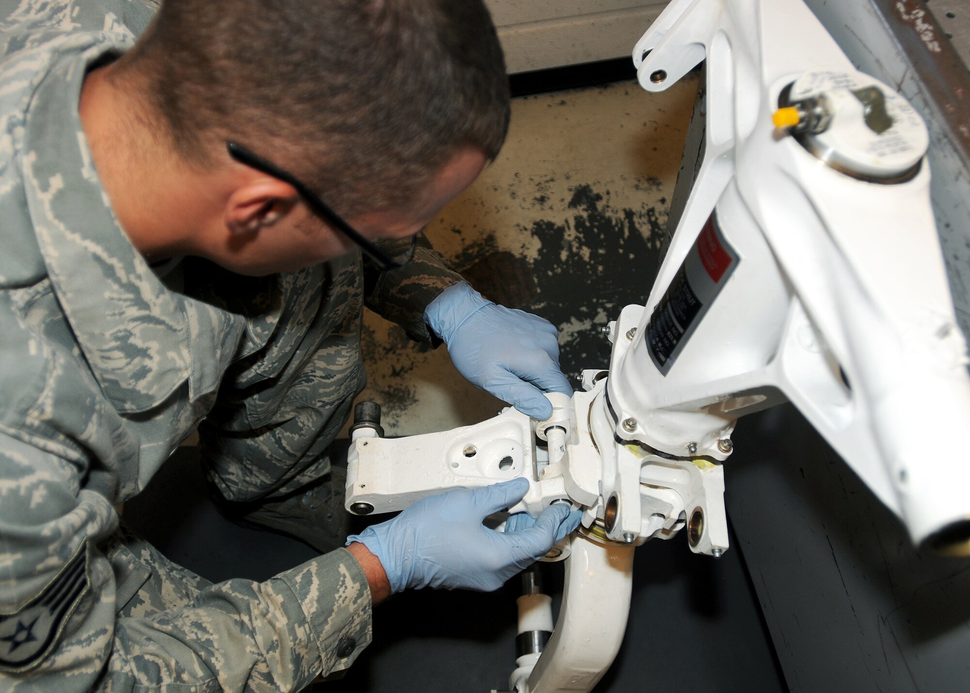 Staff Sgt. Joshua Walters, 31st Maintenance Squadron hydraulics craftsman, connects a torque link to an F-16 Fighting Falcon nose landing gear shock strut July 14 at the hydraulics back shop before testing.  To test aircraft parts, the hydraulics team uses a test unit that recreates the conditions of the part on an F-16 Fighting Falcon.  (U.S. Air Force photo/Senior Airman Tabitha M. Lee)