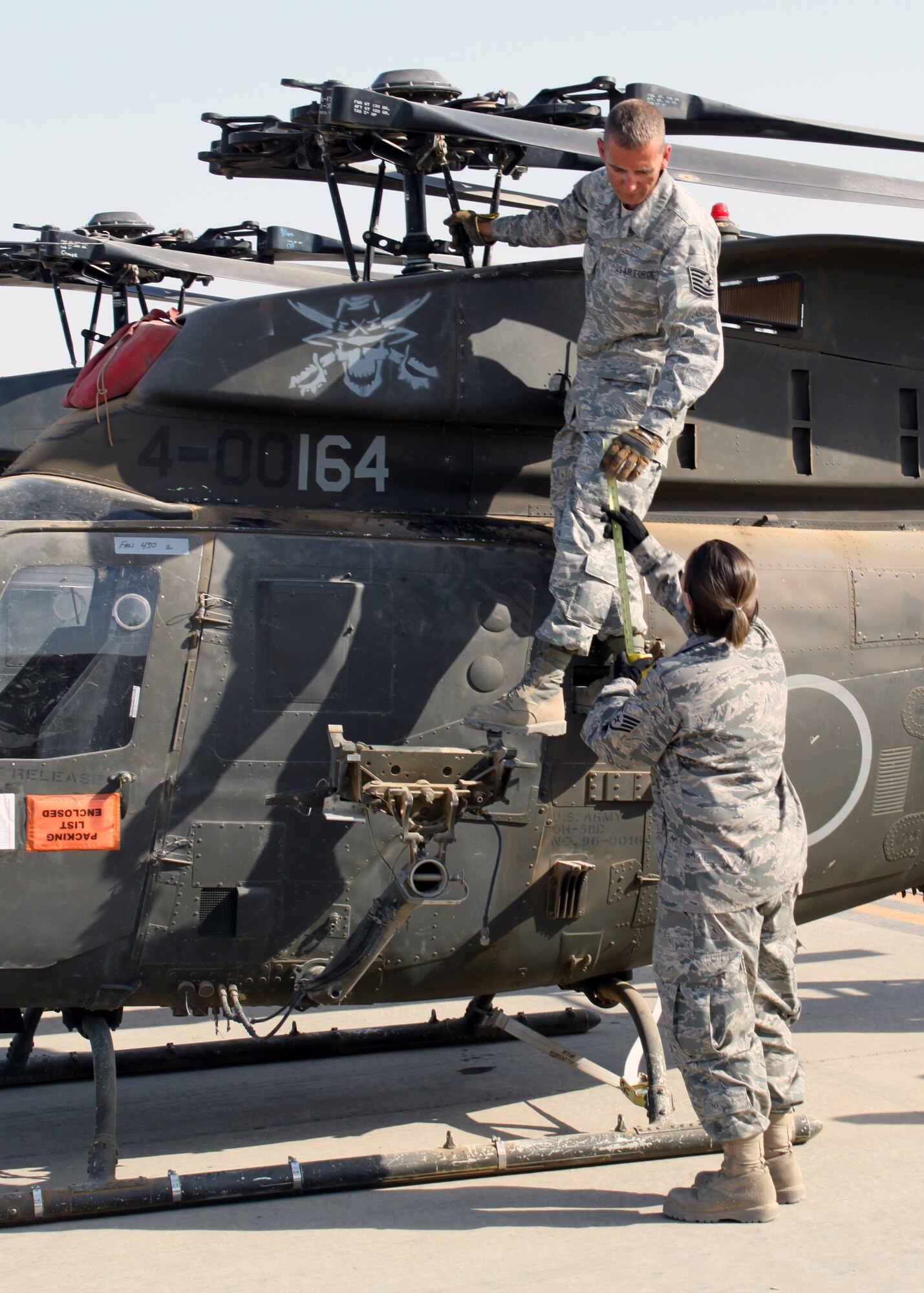 Tech. Sgt. James Dupuis and Staff Sgt. Angel Lombana, 332nd Expeditionary Logistics Readiness Squadron, measure the height of an Army OH-58 Kiowa helicopter during transport preparation July 15, 2010, at Joint Base Balad, Iraq.  Fitting helicopters into cargo aircraft is “a lot like Tetris” according to one of the 332 ELRS Airmen – each one has to fit a certain way to maximize space usage.  Both Sergeants Dupuis and Lombana are deployed from the 42nd Aerial Port Squadron, Westover Air Reserve Base, Mass. (U.S. Air Force photo/Staff Sgt. Stacy Fowler)