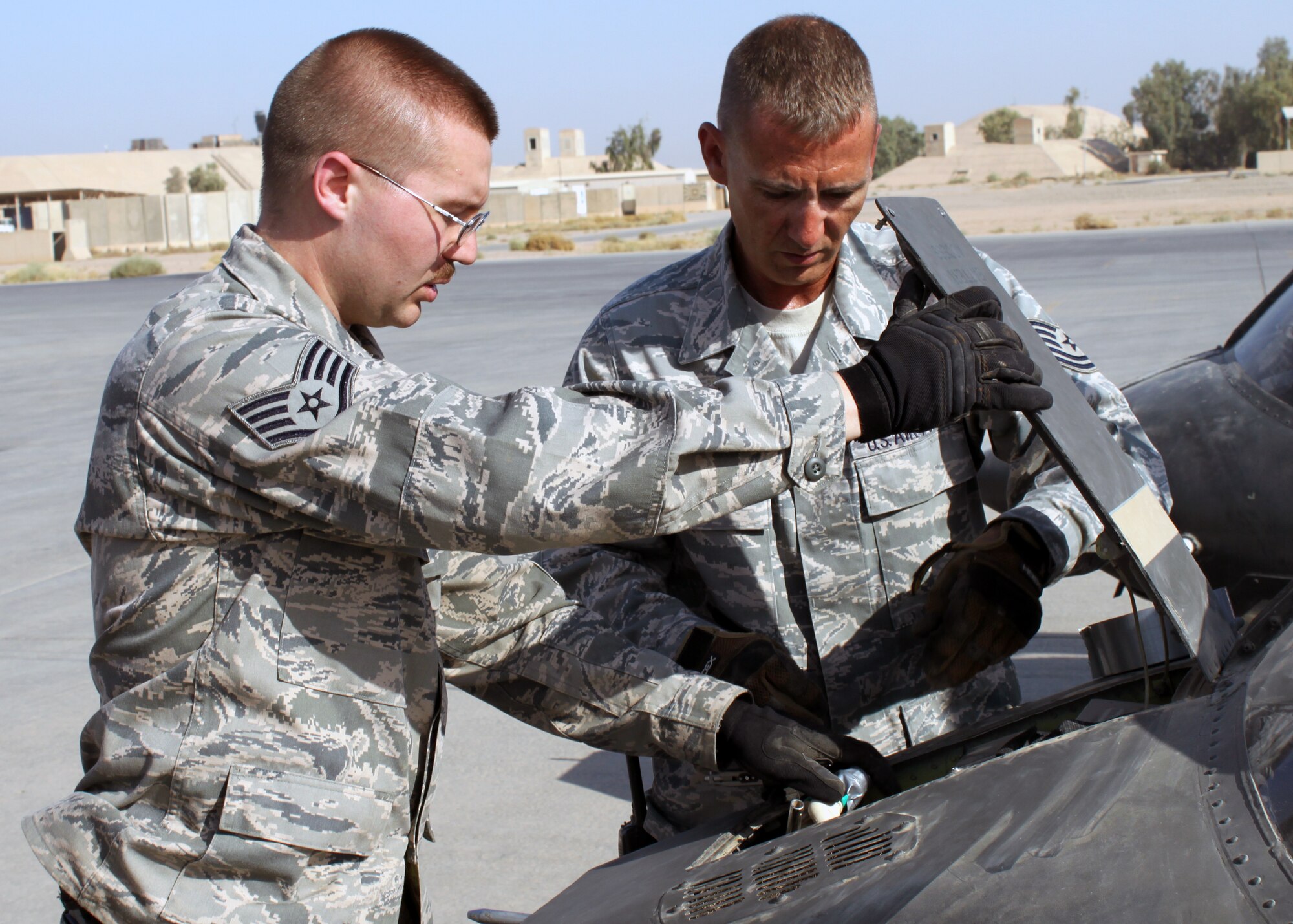 Staff Sgt. Ryan Hockerlotz, left, and Tech. Sgt. James Dupuis, 332nd Expeditionary Logistics Readiness Squadron, disconnect the battery of an Army OH-58 Kiowa helicopter during transport preparation July 15, 2010, at Joint Base Balad, Iraq.  332 ELRS Airmen conduct inventory inspections to make sure each aircraft is airworthy, such as disconnecting power sources like batteries. Sergeants Hockerlotz and Dupuis are both deployed from the 42nd Aerial Port Squadron, Westover Air Reserve Base, Mass. (U.S. Air Force photo/Staff Sgt. Stacy Fowler)