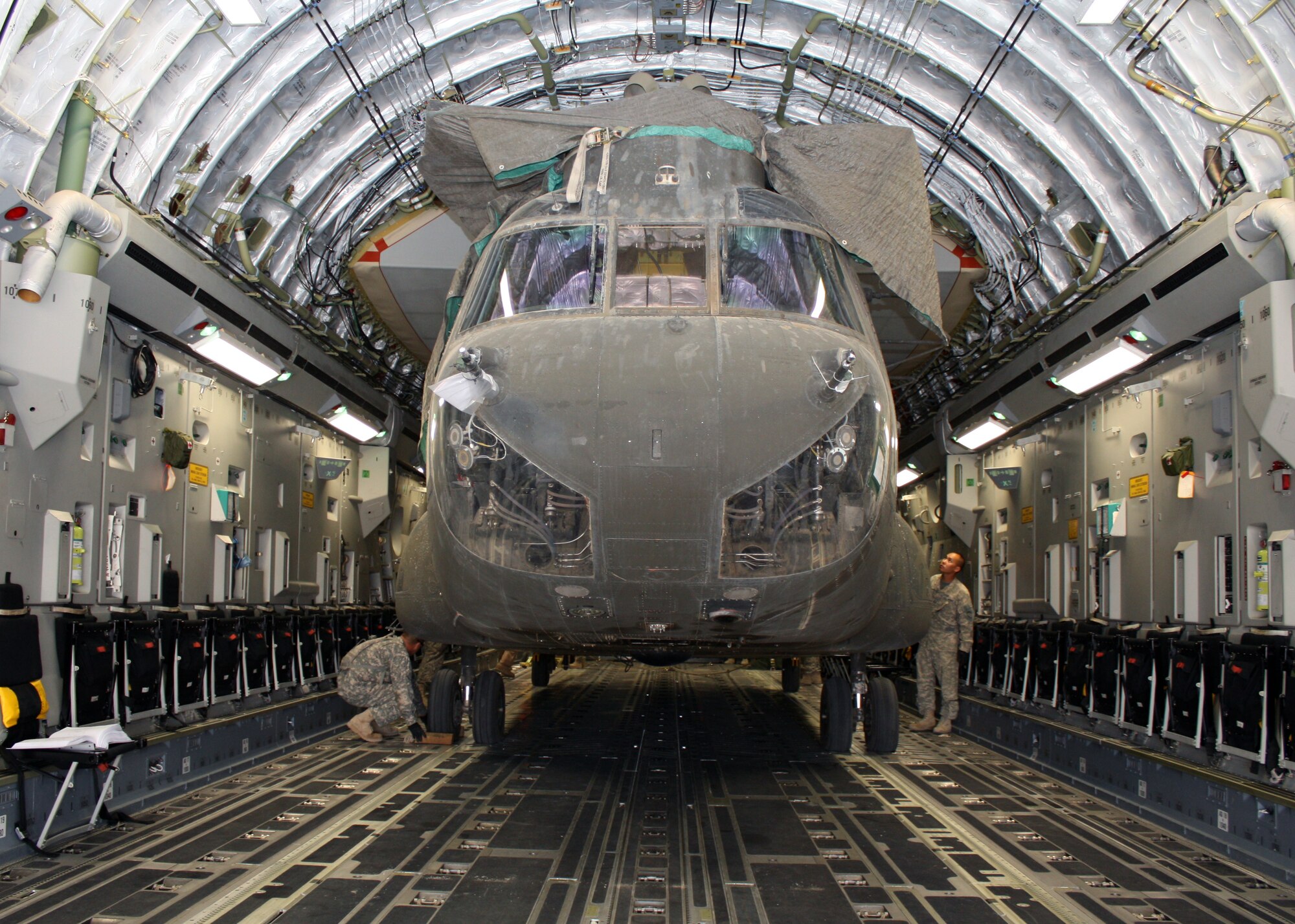 Army Capt. Stephen Lee, 209th Aviation Support Battalion strategic air load officer in charge, inspects an Army CH-47 Chinook helicopter after being loaded into a C-17 Globemaster III July 13, 2010, at Joint Base Balad, Iraq.  Ensuring the helicopter stays in place during travel is crucial for both the aircraft’s safety and those onboard. Captain Lee is deployed from the 25th Combat Aviation Brigade at Wheeler Army Airfield, Hawaii.  (U.S. Air Force photo/Staff Sgt. Stacy Fowler)